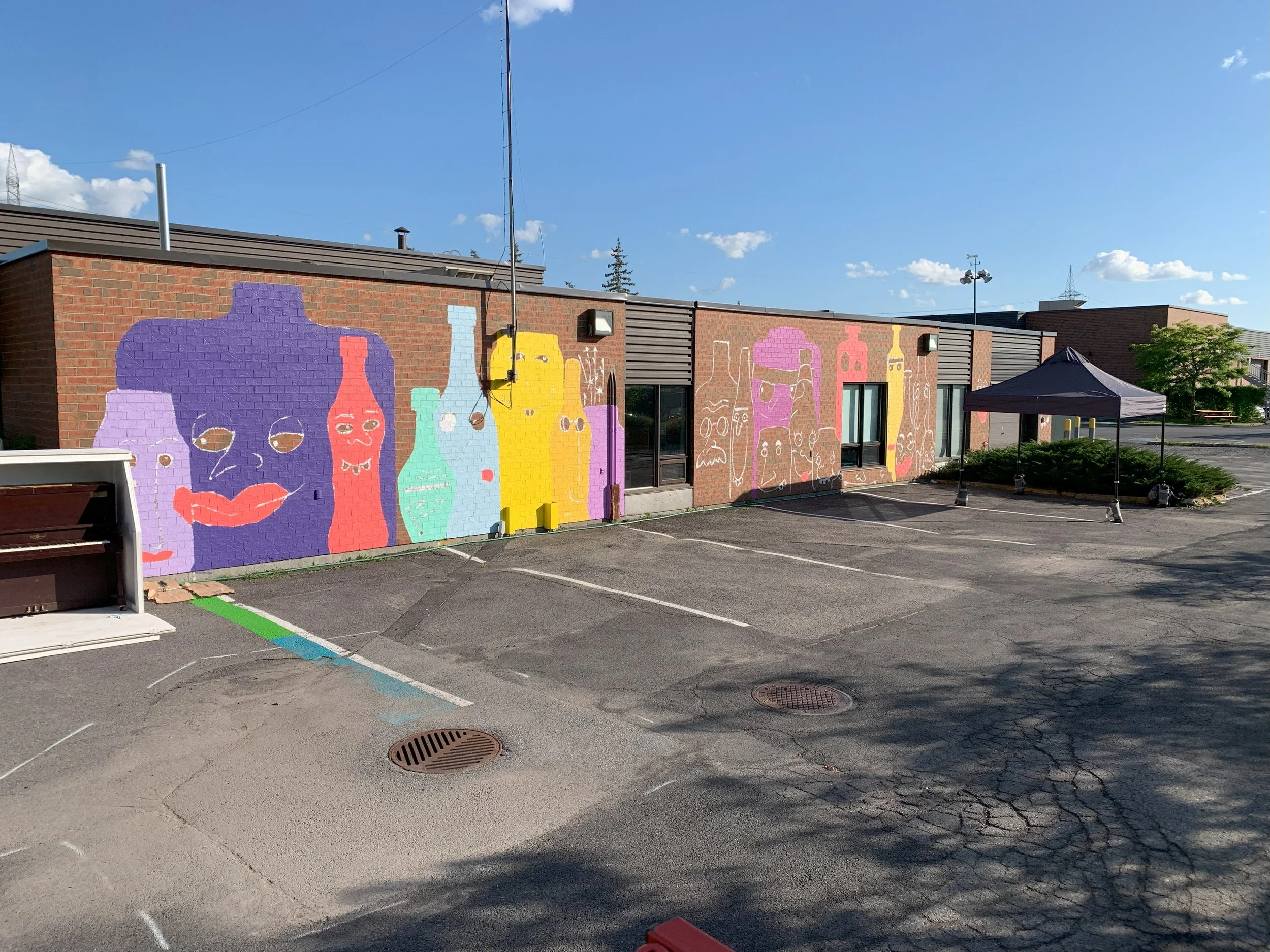 edgar artiste muraliste entrain de peindre la murale exterieur la famille des verres à candiac