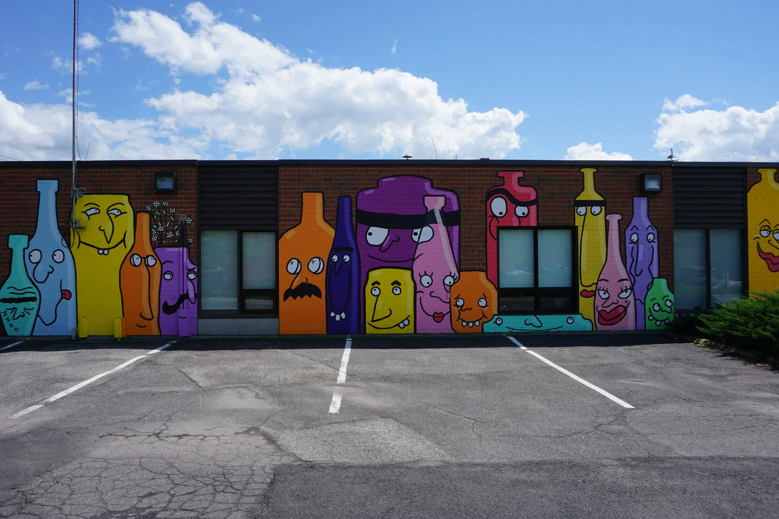 edgar artiste muraliste entrain de peindre la murale exterieur la famille des verres à candiac