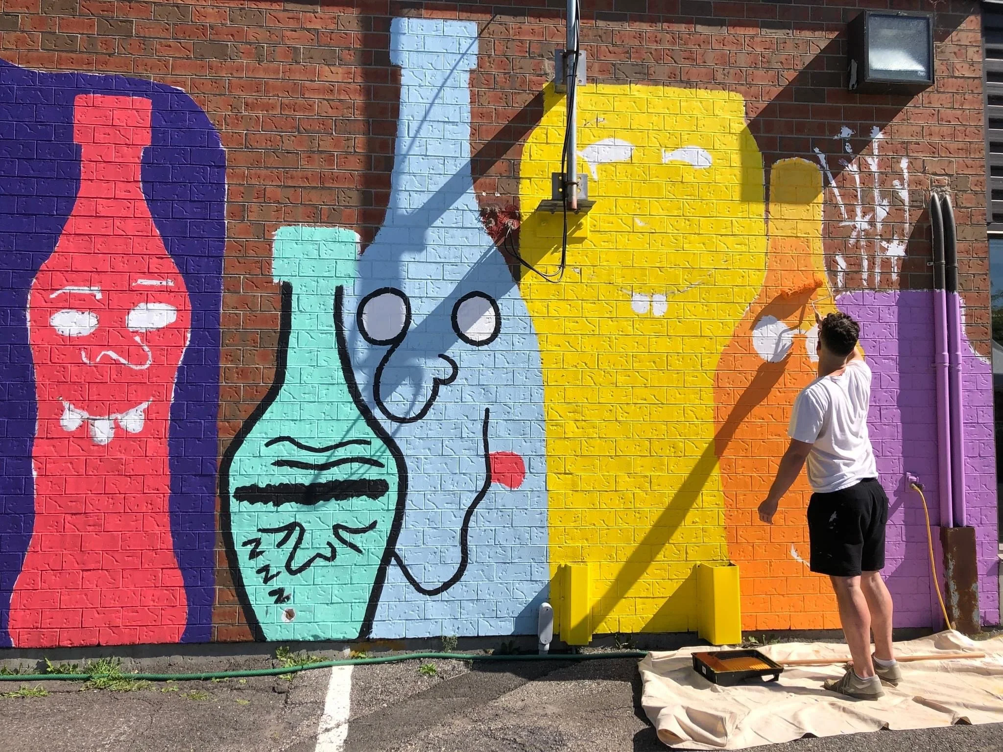 edgar artiste muraliste entrain de peindre la murale la famille des verres