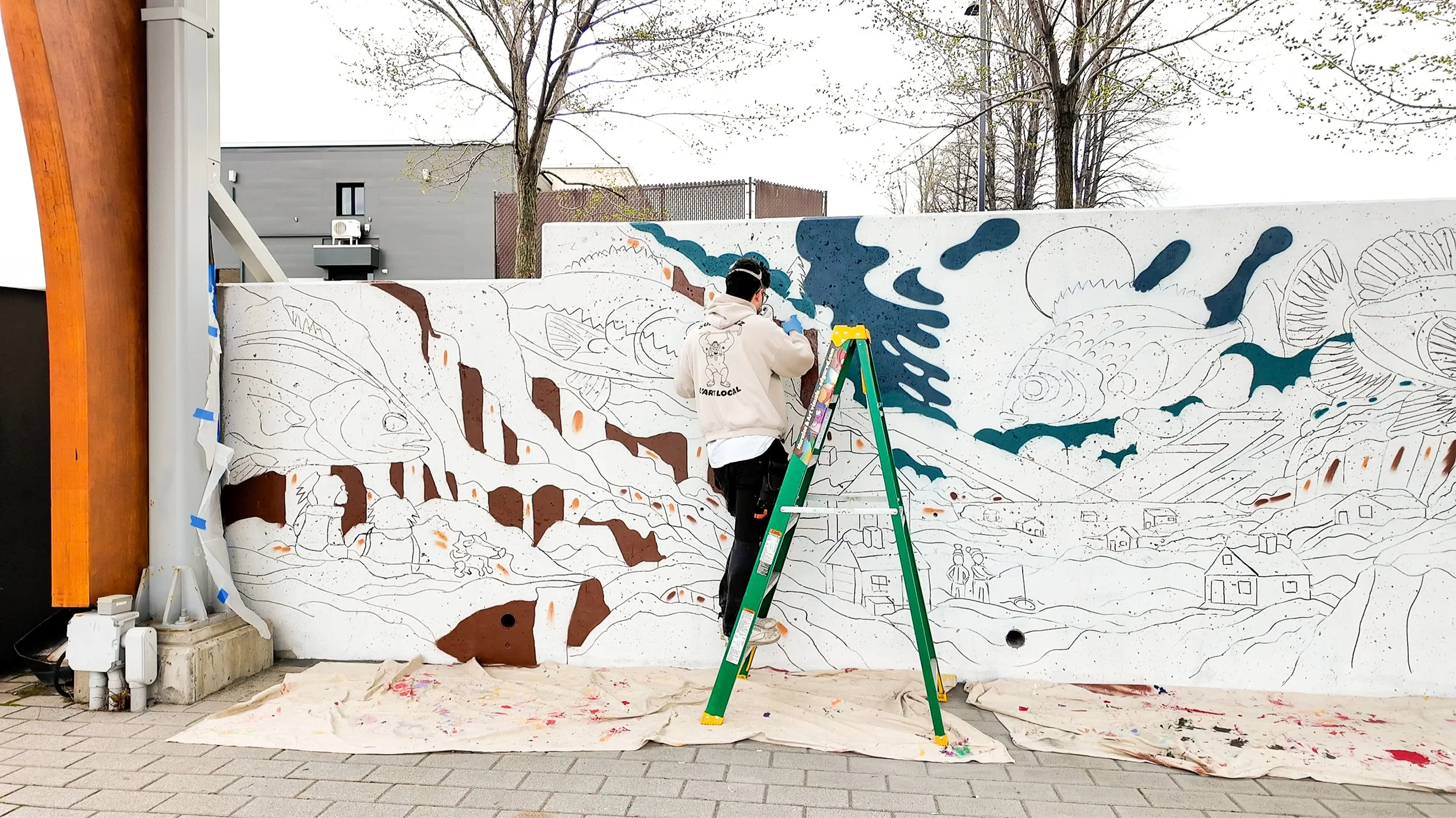 Edgar entrain de peindre la murale au saguenay