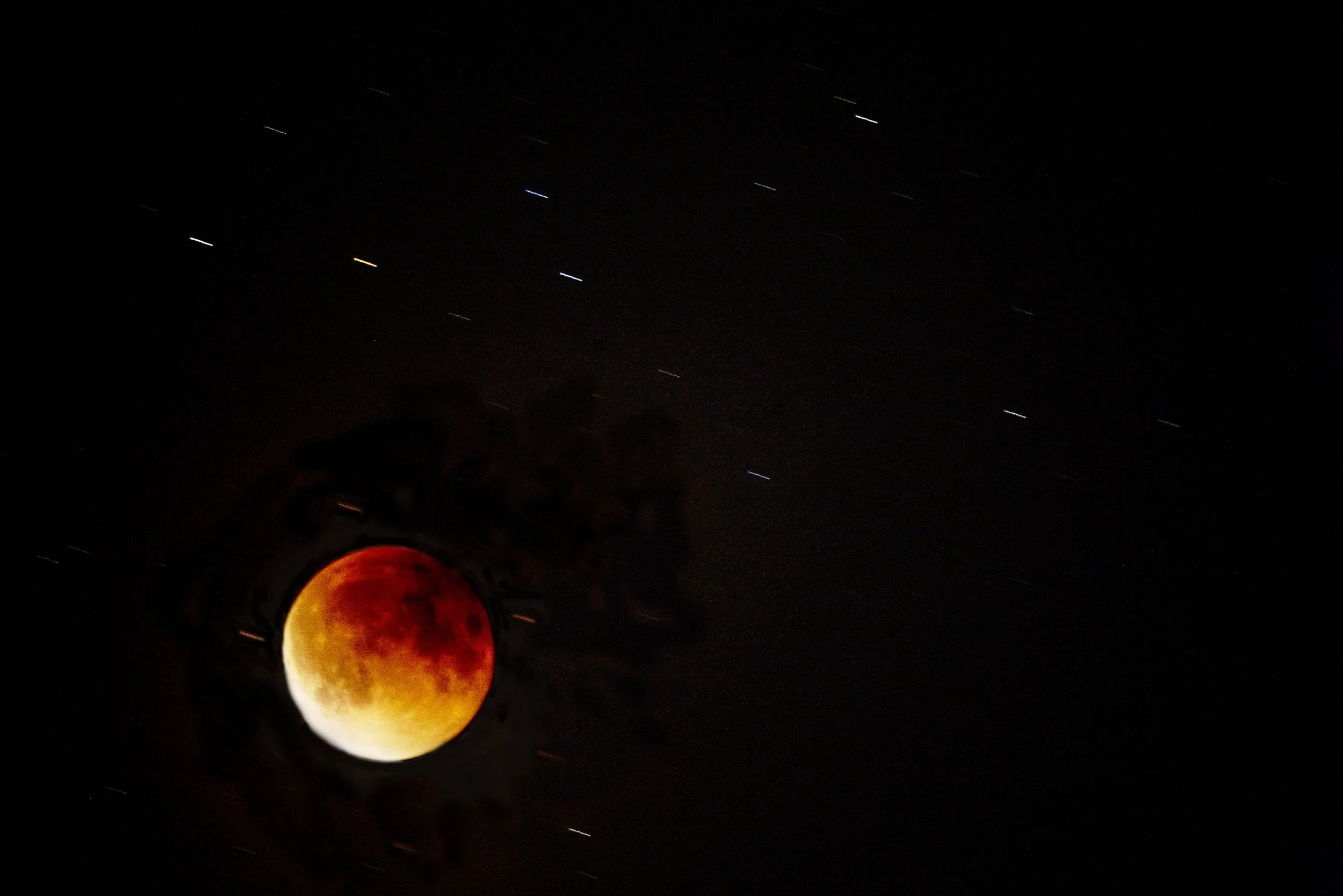 Blood moon during lunar eclipse with stars in the night sky