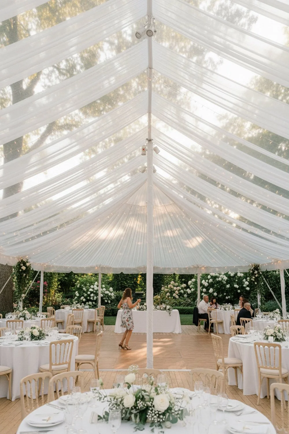 The wedding venue’s natural greenery "ghosted" through a sheer reception tent.