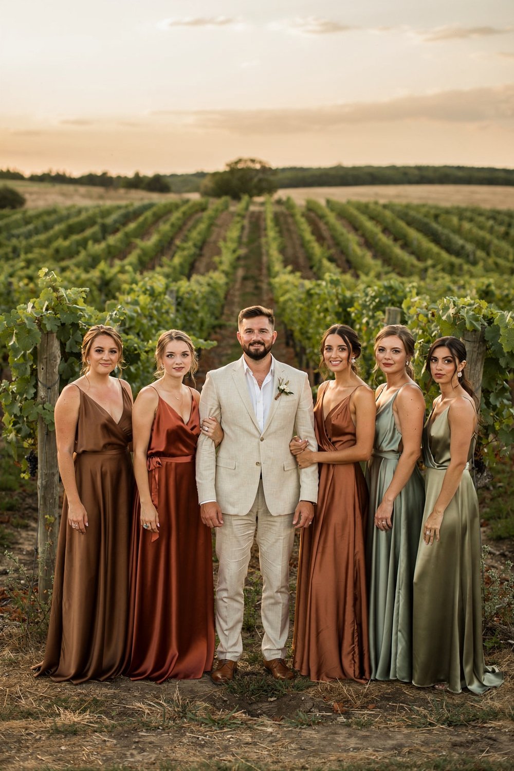 Wedding party fashion in earthy tones of mocha and sage green at a sunset vineyard.