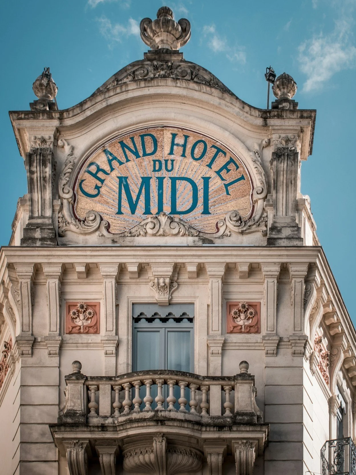 Façade de l'hôtel "Grand Hôtel du Midi" avec son architecture ornée et une enseigne au sommet.