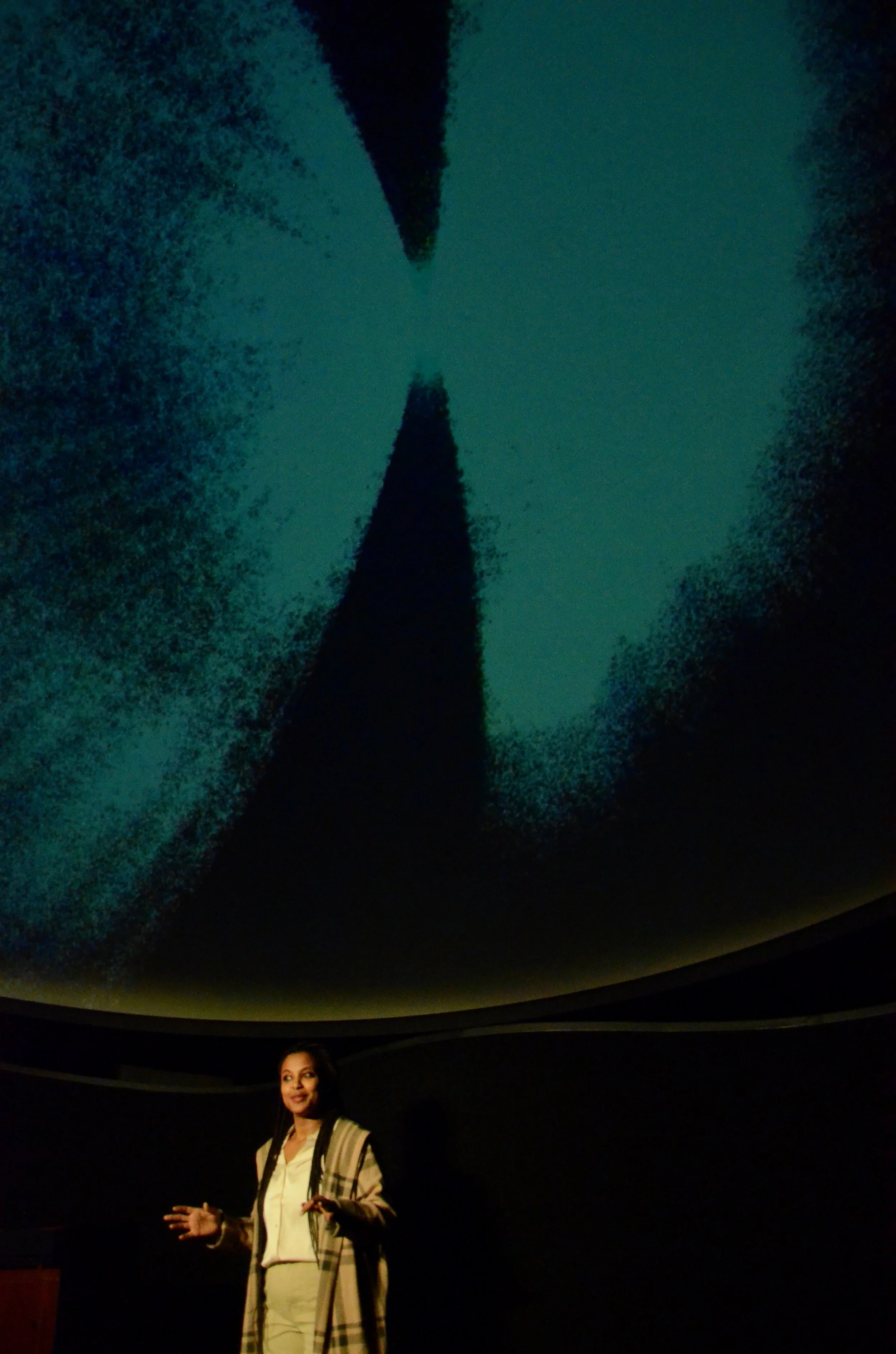 Woman giving a presentation in front of a large projection of a star.