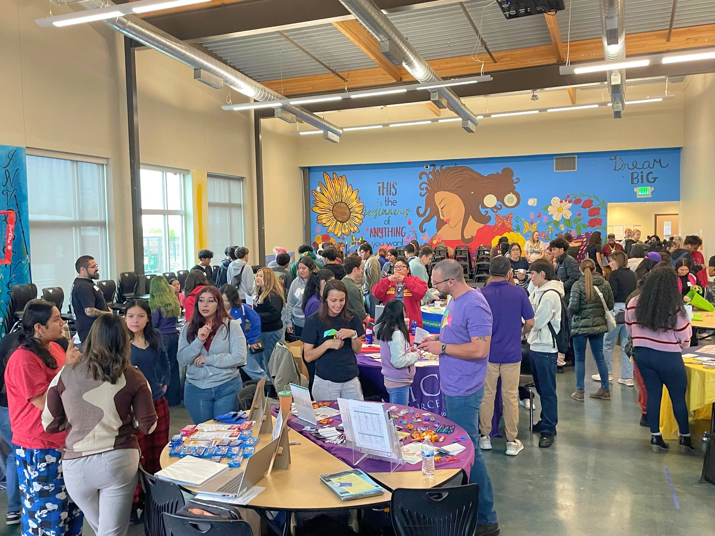 A room full of students visiting job booths in a converted lunch room at a local alternative high school