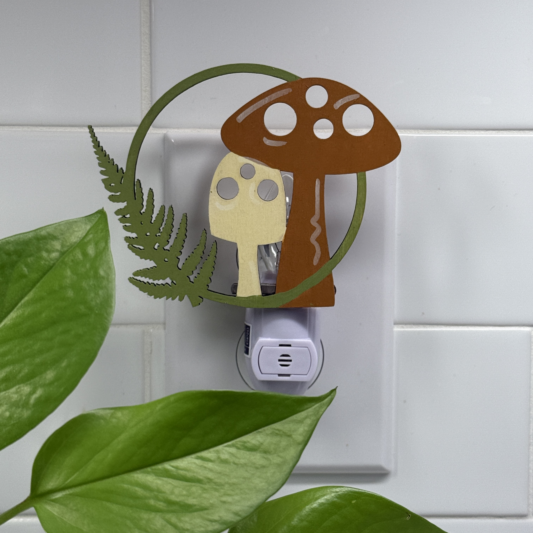 Hand-painted mushroom night light in red, cream, and green against white tile background
