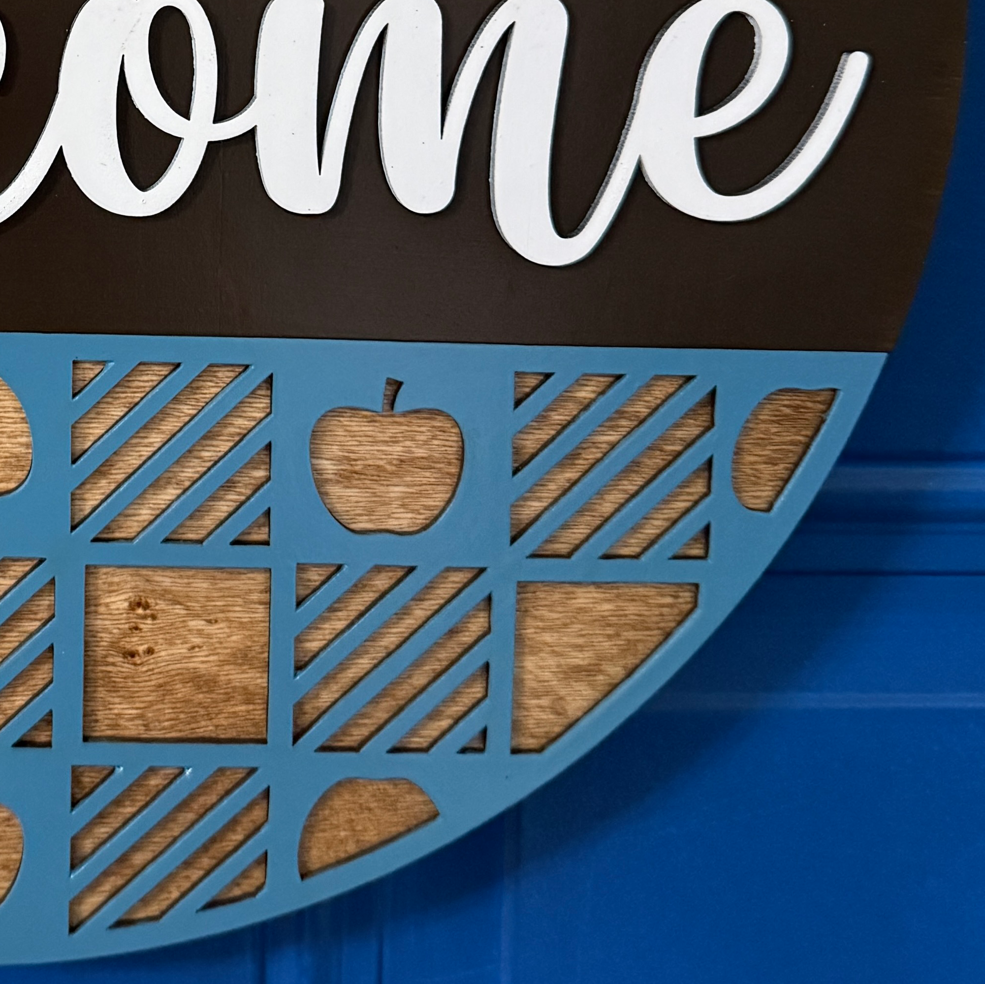 Close-up of lower basket weave design with blue accents and apple cutouts