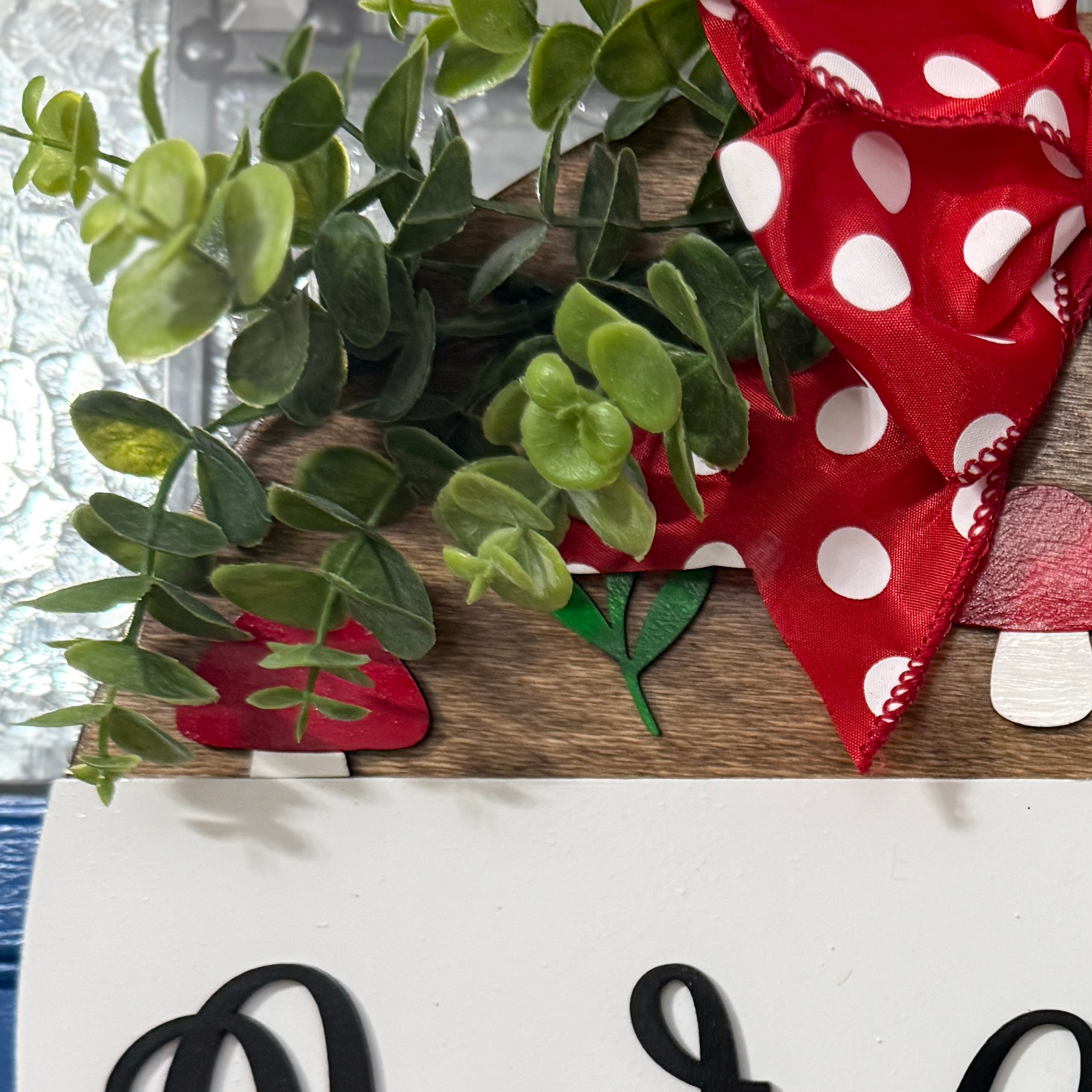 Cottagecore mushroom welcome sign with greenery and red polka dot bow