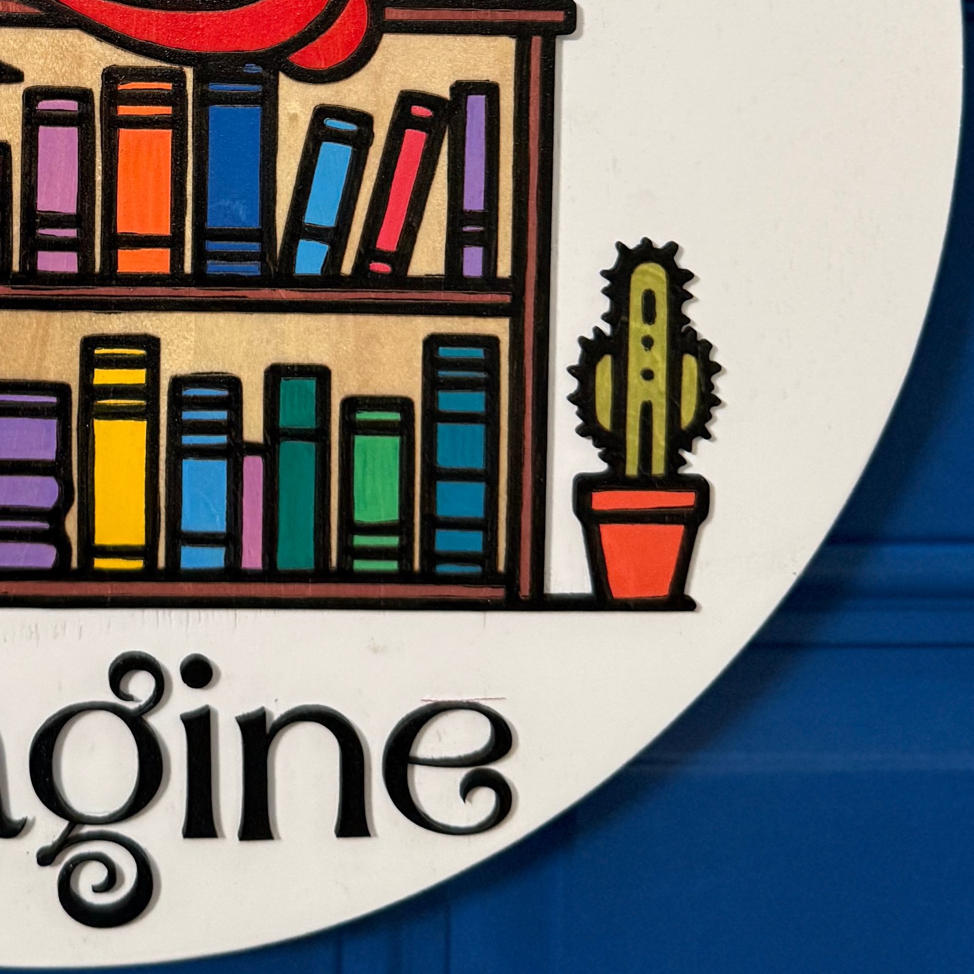 Close-up of lower section showing “imagine” script text in black on white background