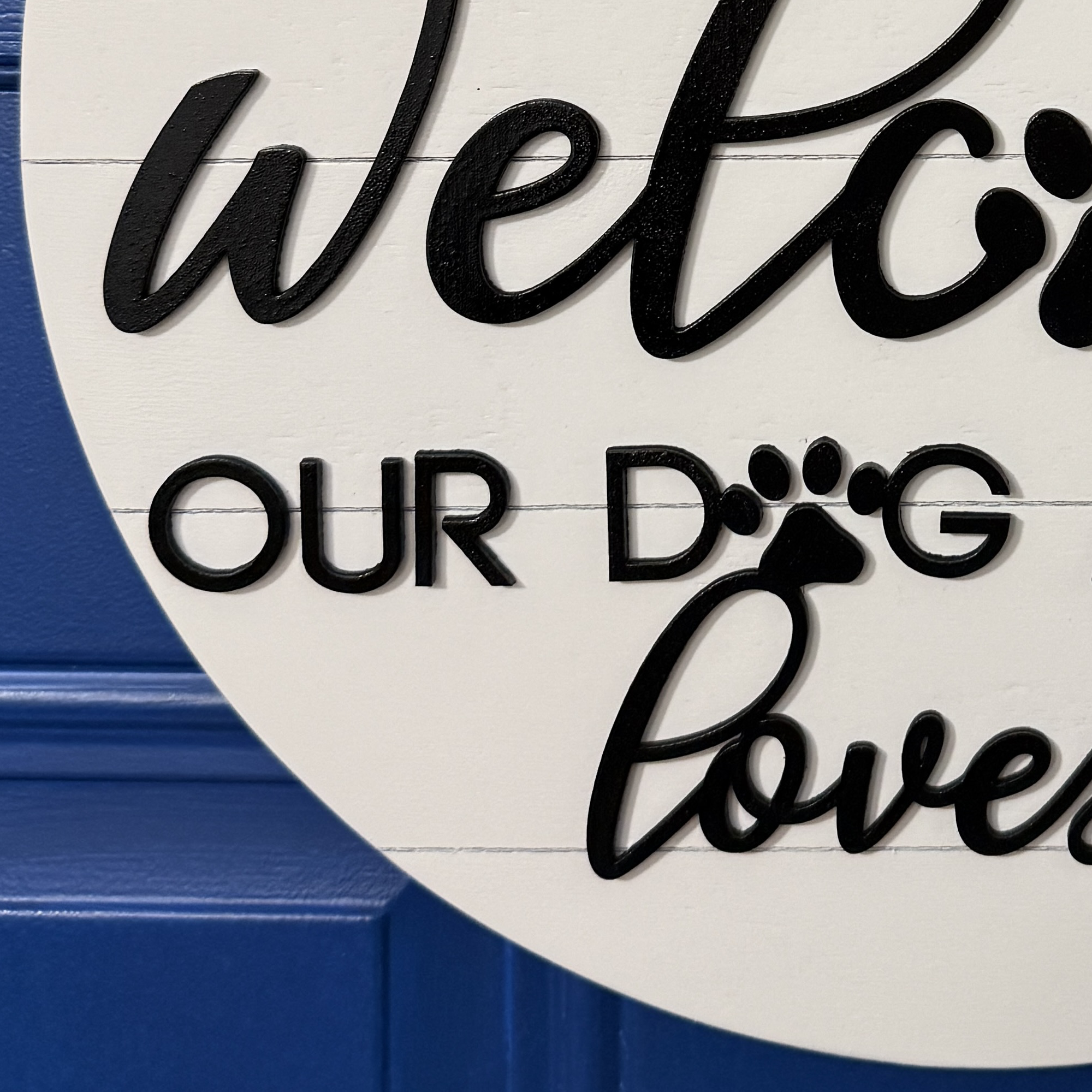 Partial crop of welcome lettering with paw print replacing the letter “o”