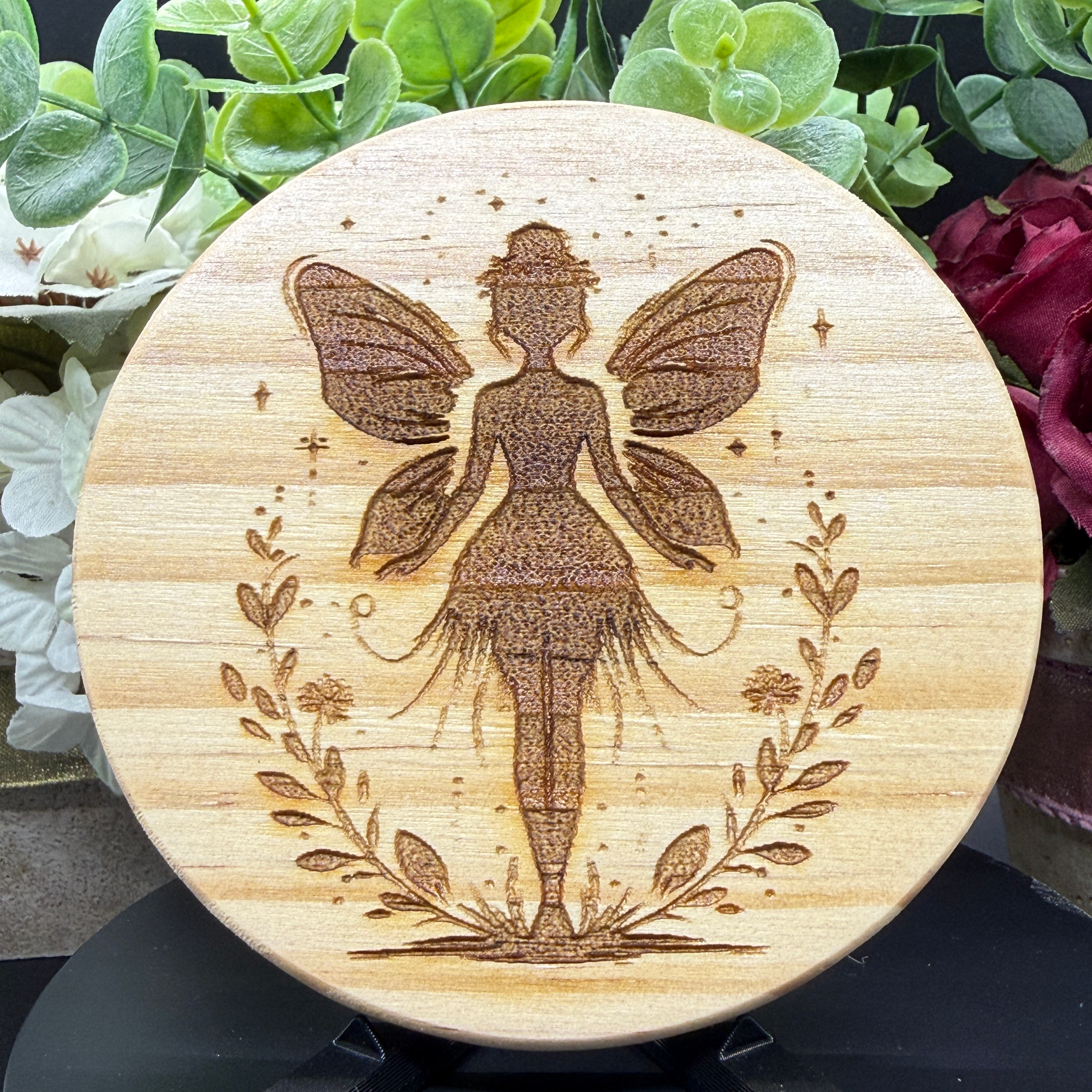 Engraved fairy silhouette with wings on wood coaster