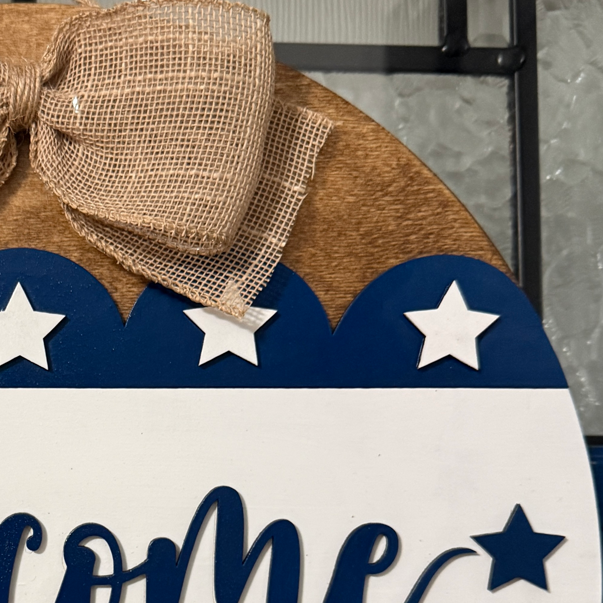 Close-up of layered welcome script with white stars and patriotic blue banner.