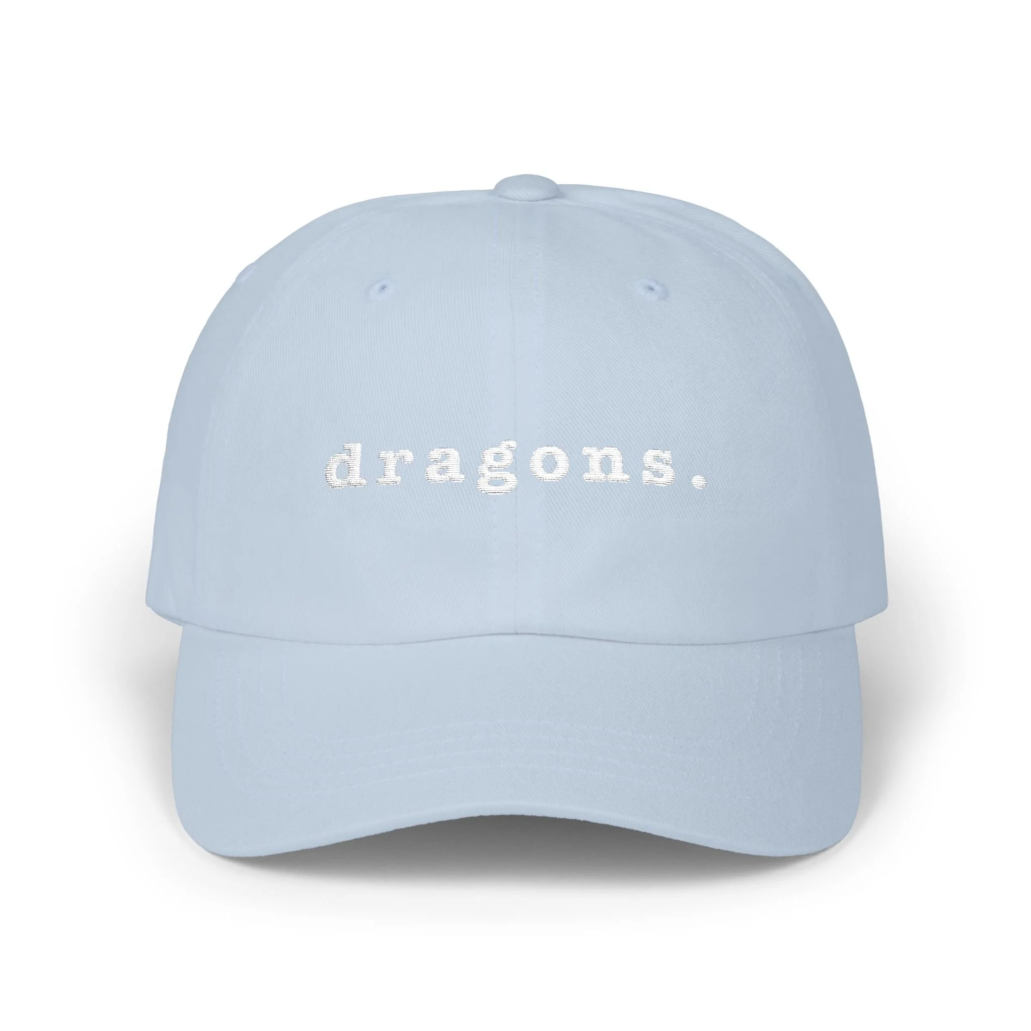 Light blue dad cap on white background displaying embroidered “dragons.” text on the front.