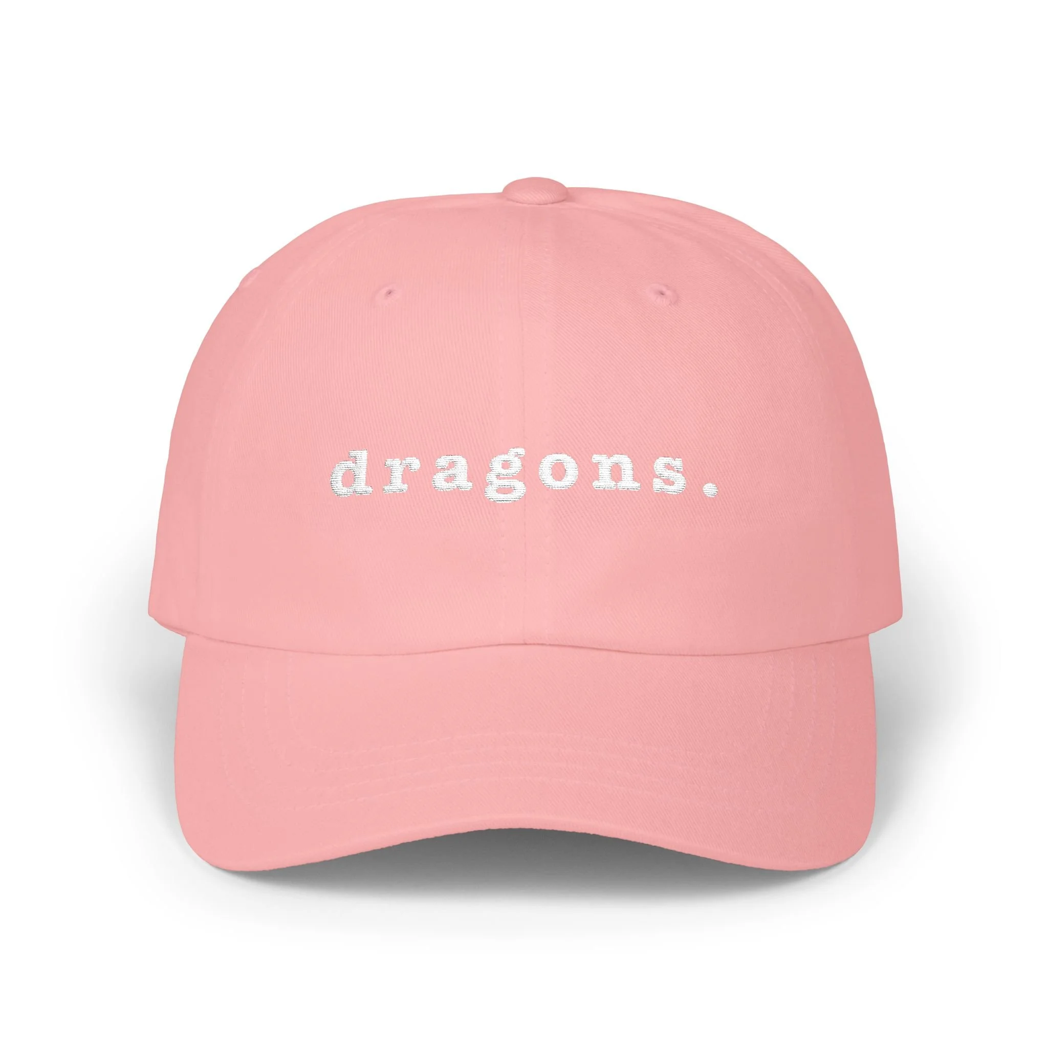 Pink dad cap on white background displaying embroidered “dragons.” text on the front.