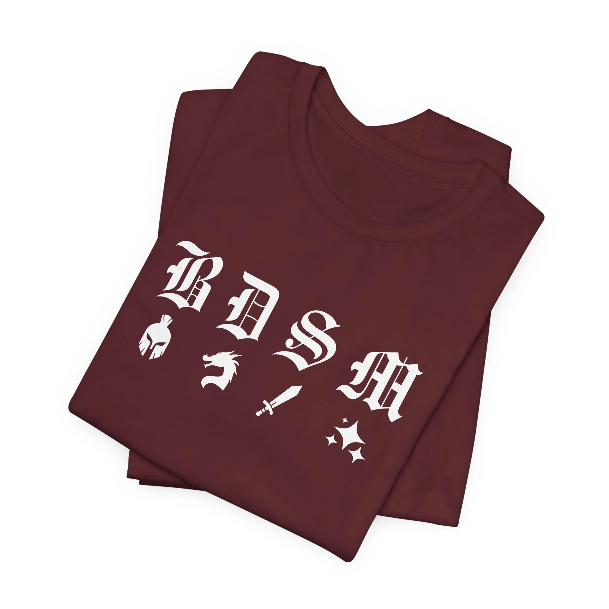 Folded maroon t-shirt with white fantasy BDSM design featuring helmet, dragon, sword, and sparkles