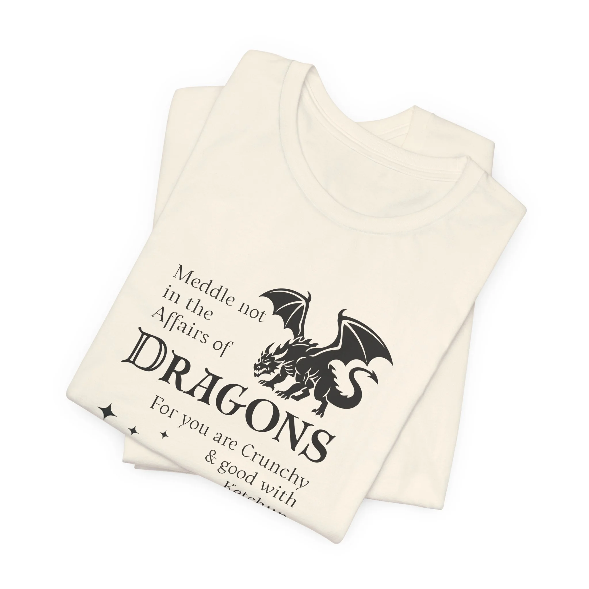 Folded natural color dragon quote t-shirt featuring black dragon artwork and whimsical star accents.