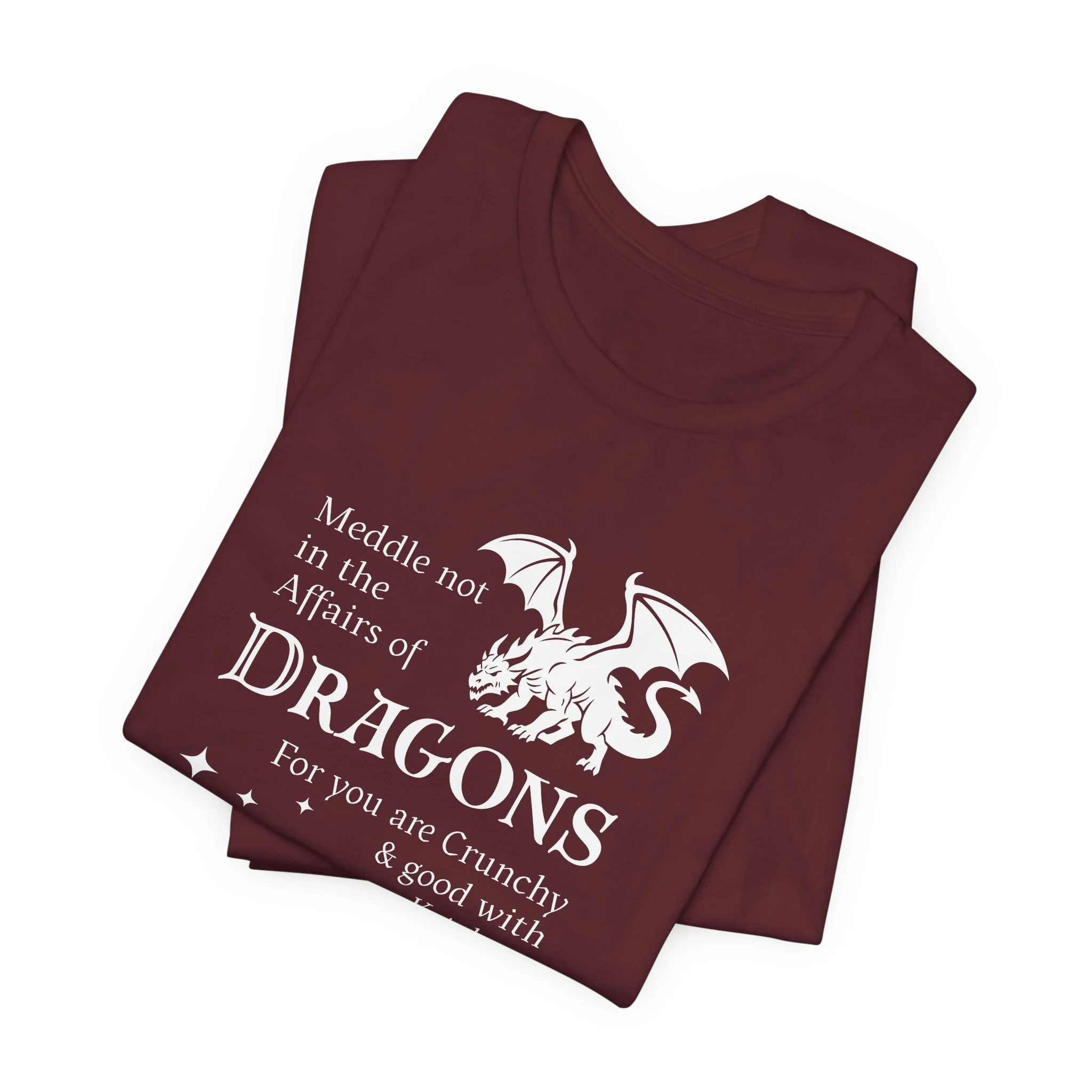 Folded maroon dragon quote t-shirt with white dragon silhouette and magical star accents.