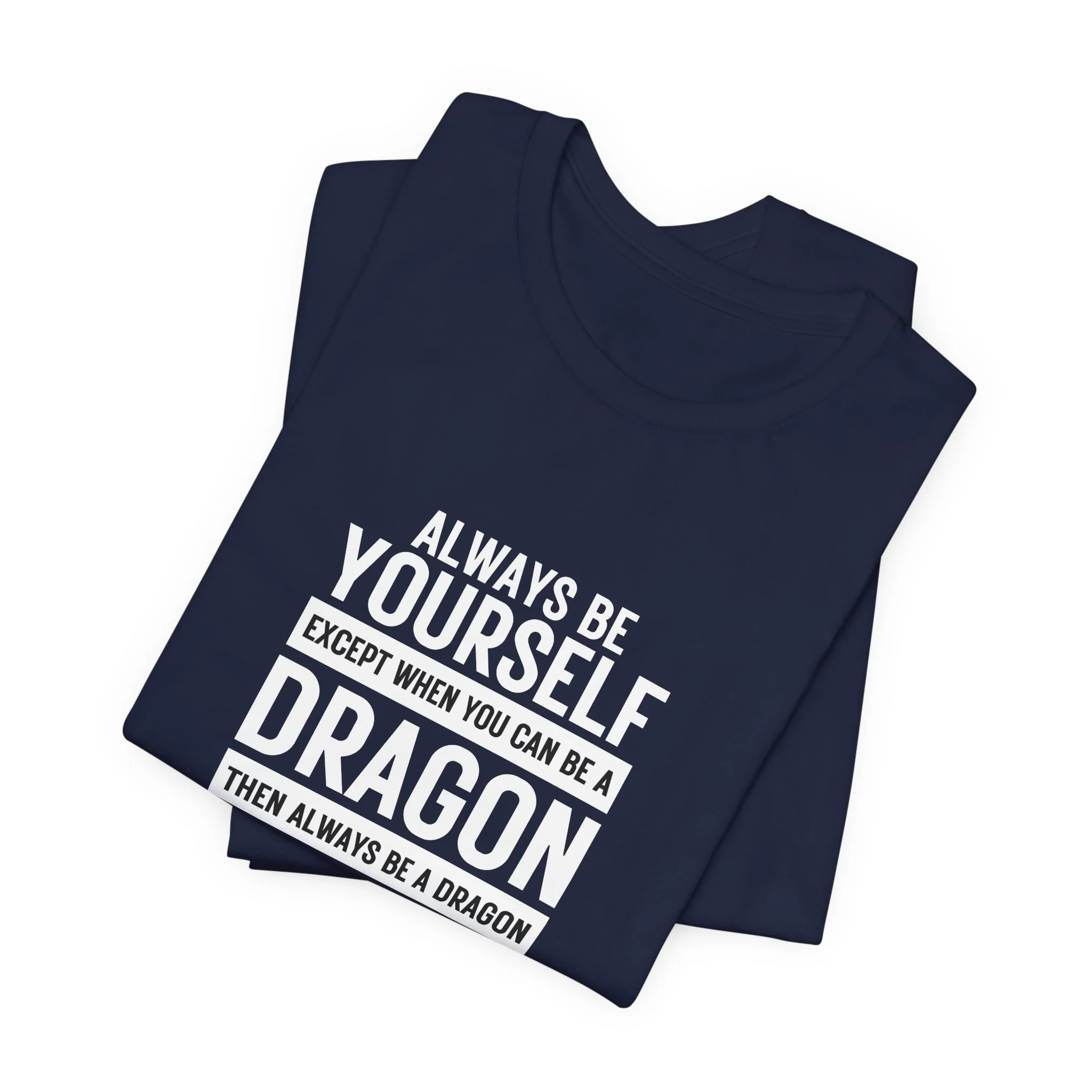 Folded navy blue unisex T-shirt with bold white text reading “Always Be Yourself Except When You Can Be a Dragon.”