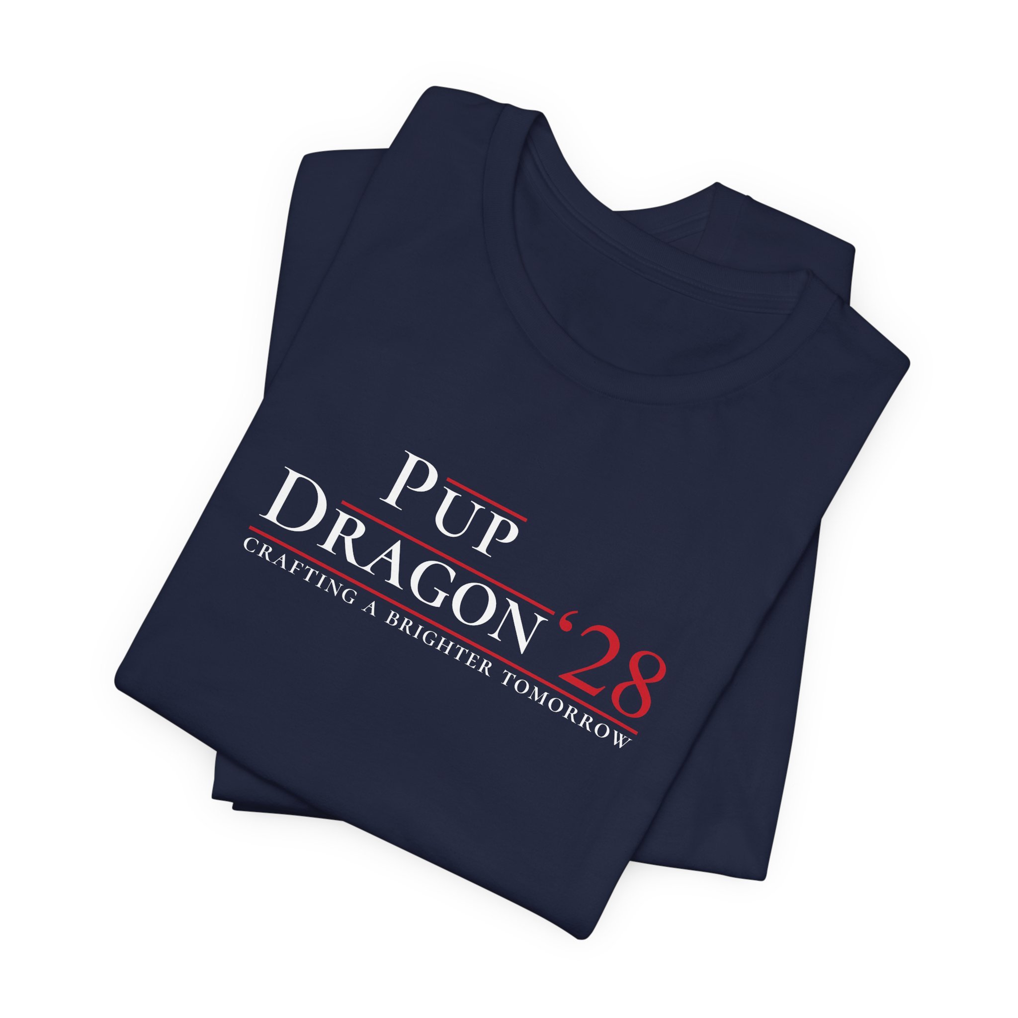 Folded navy Pup Dragon ’28 parody election-style tee stacked in flat lay.