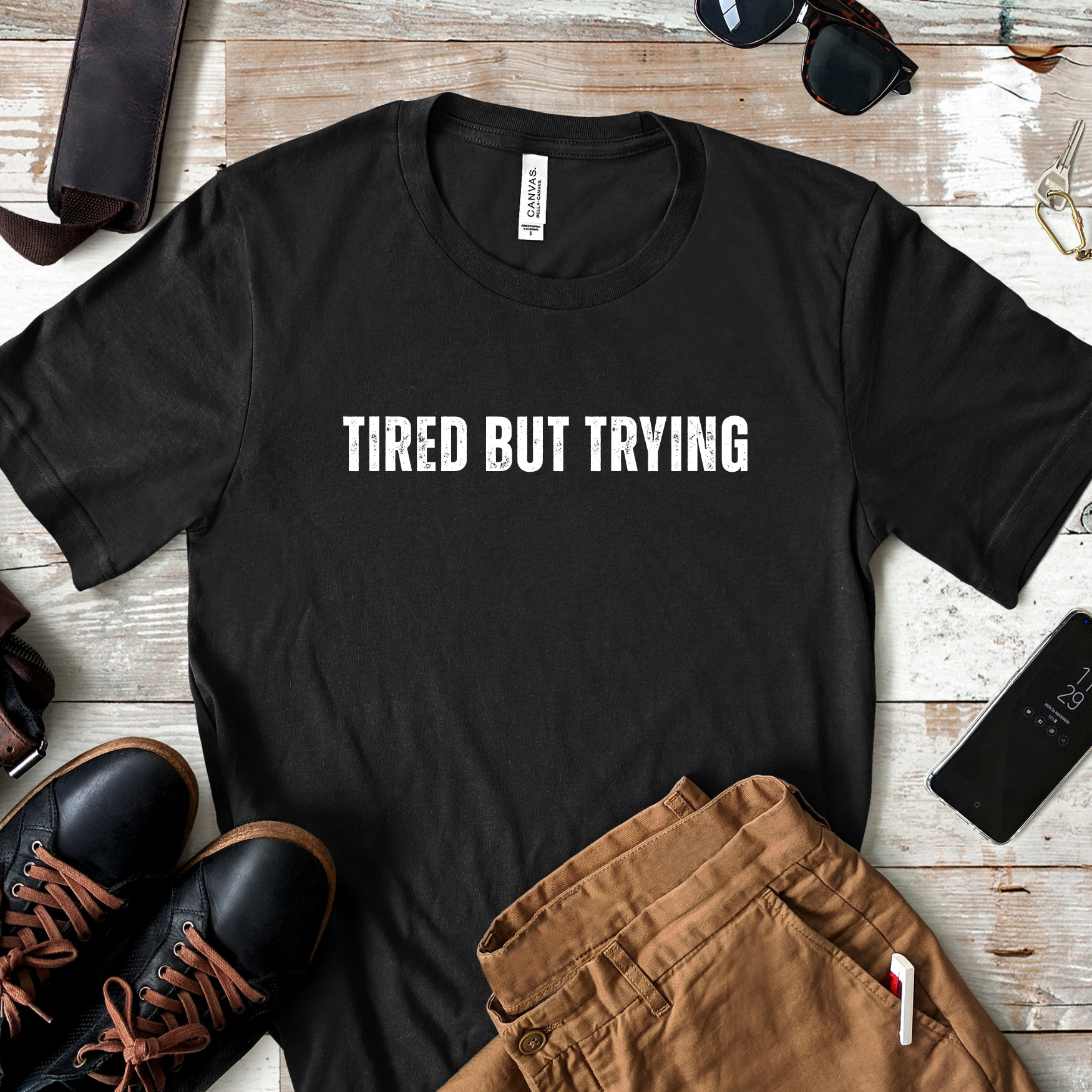 Lifestyle image of tired but trying t shirt styled with casual outfit