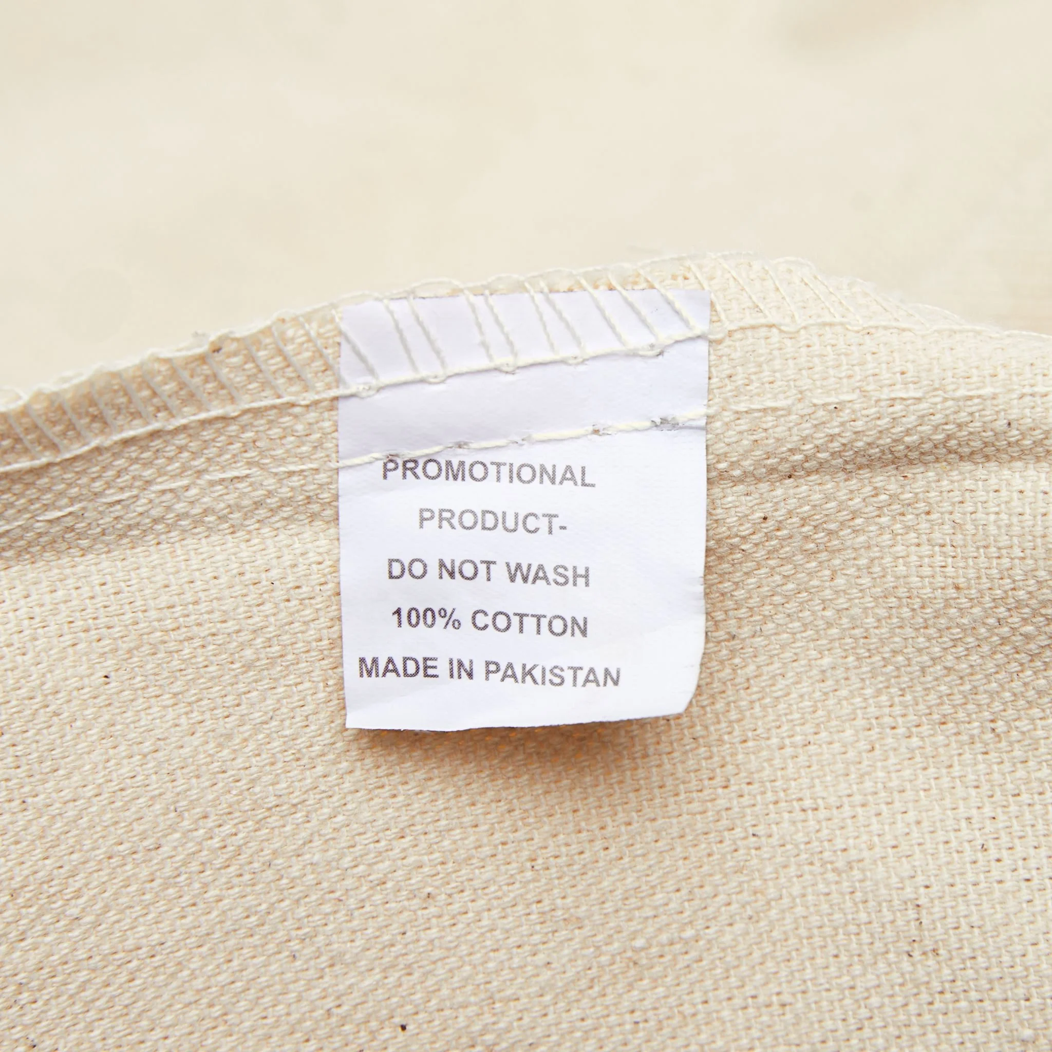 Close-up of sewn-in label on heavy cotton canvas tote bag showing material details