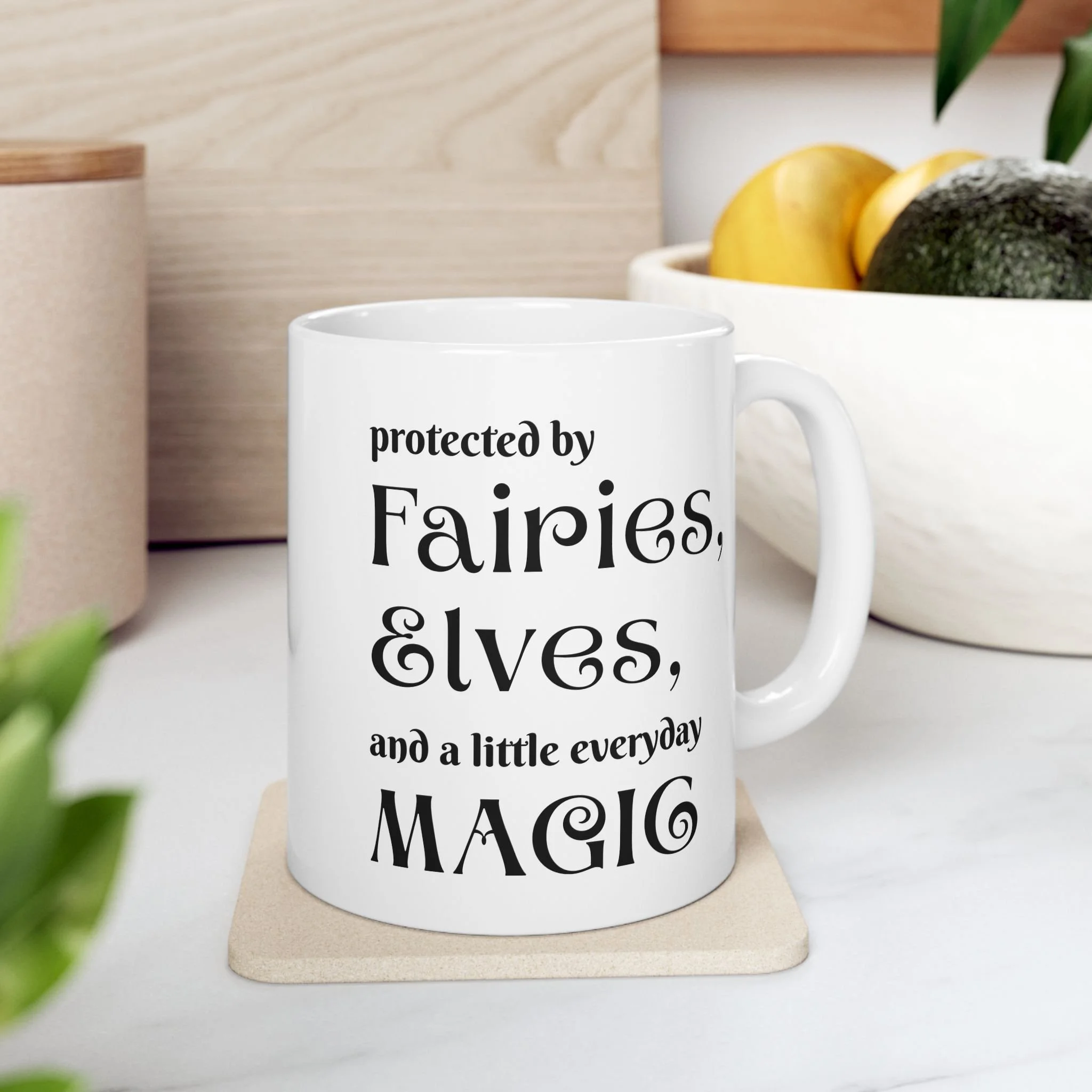 Front view of white ceramic fantasy mug with text protected by fairies elves and a little everyday magic