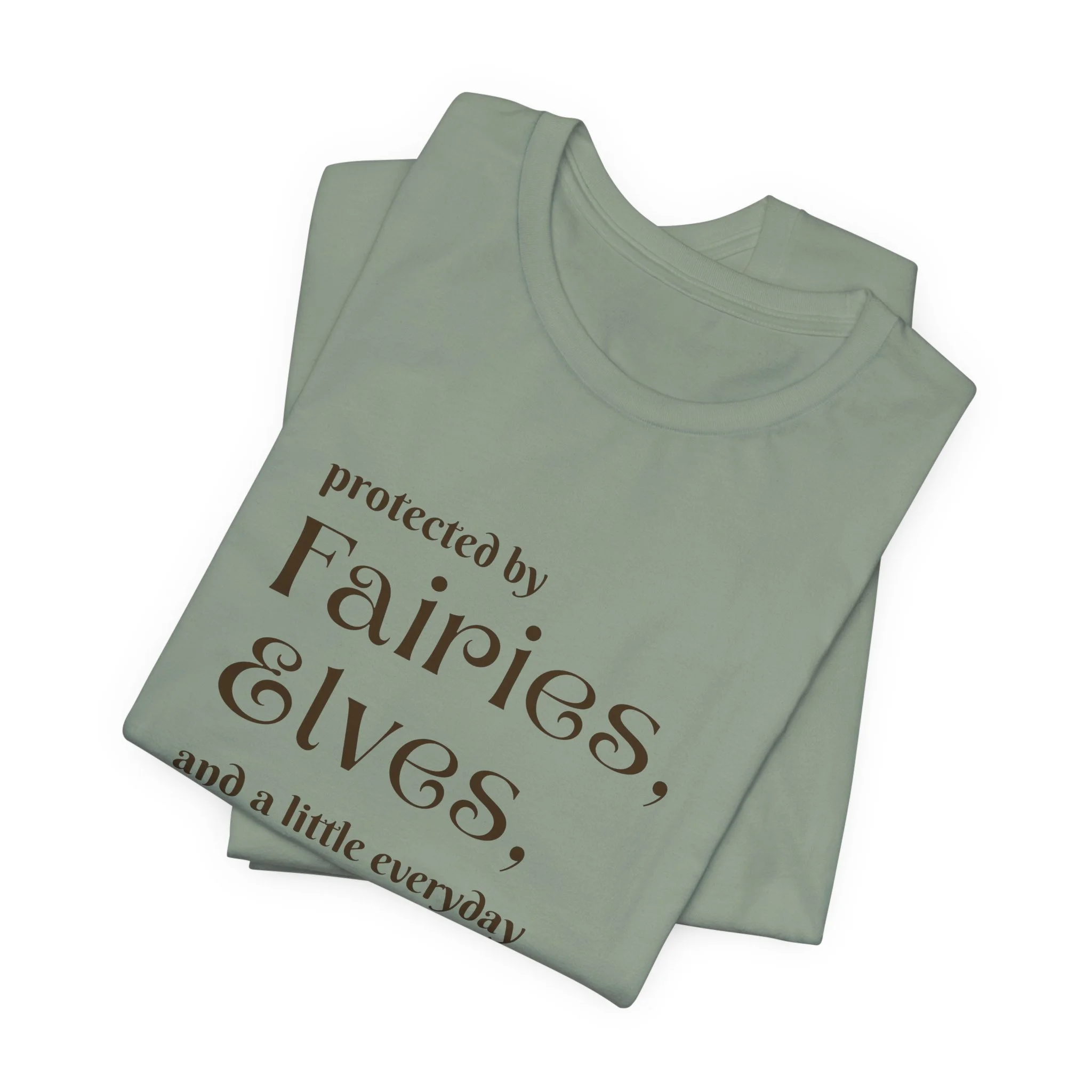 Folded sage green fantasy shirt with dark brown fairies elves everyday magic quote