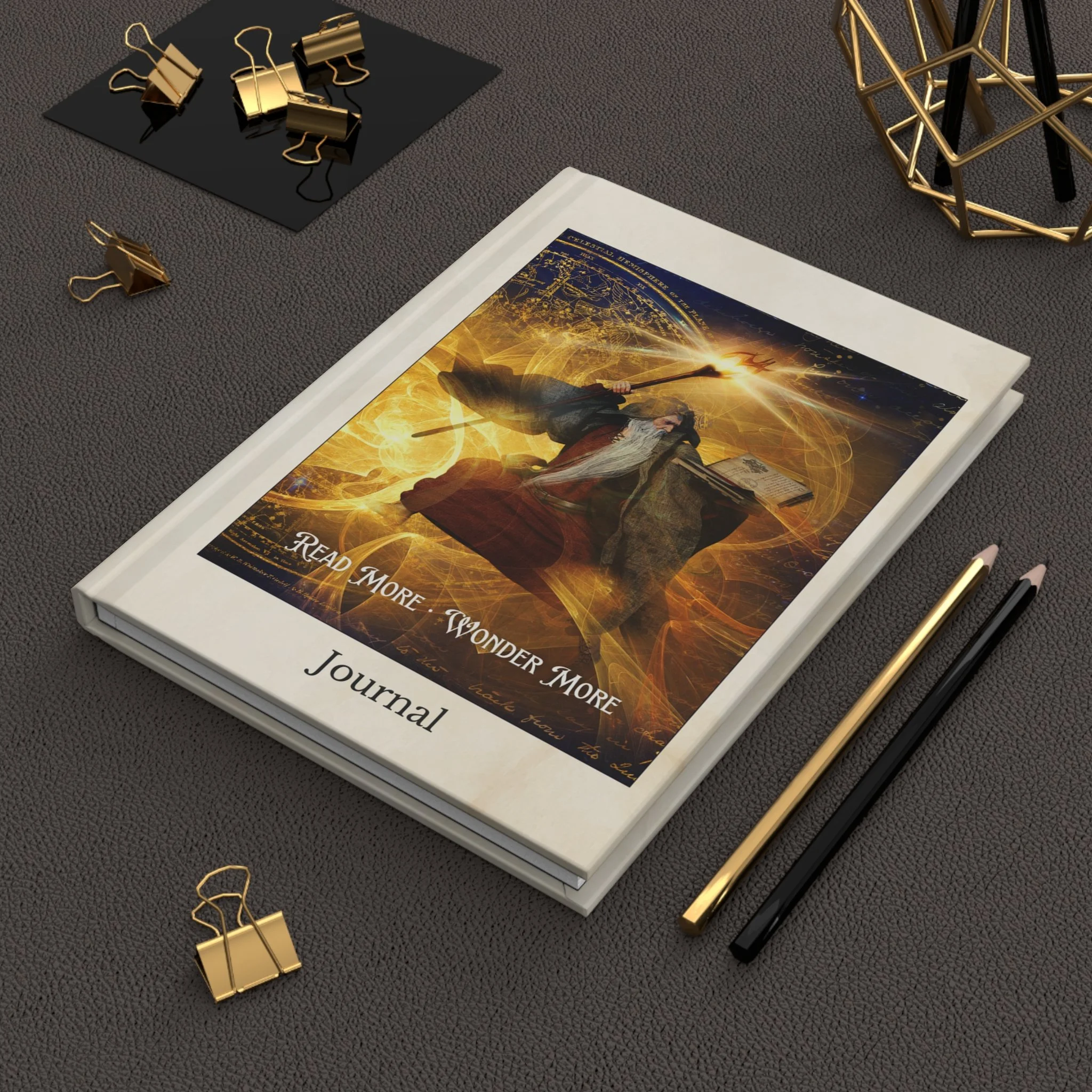 Overhead angled view of fantasy wizard journal on a dark desk with pencils and gold binder clips
