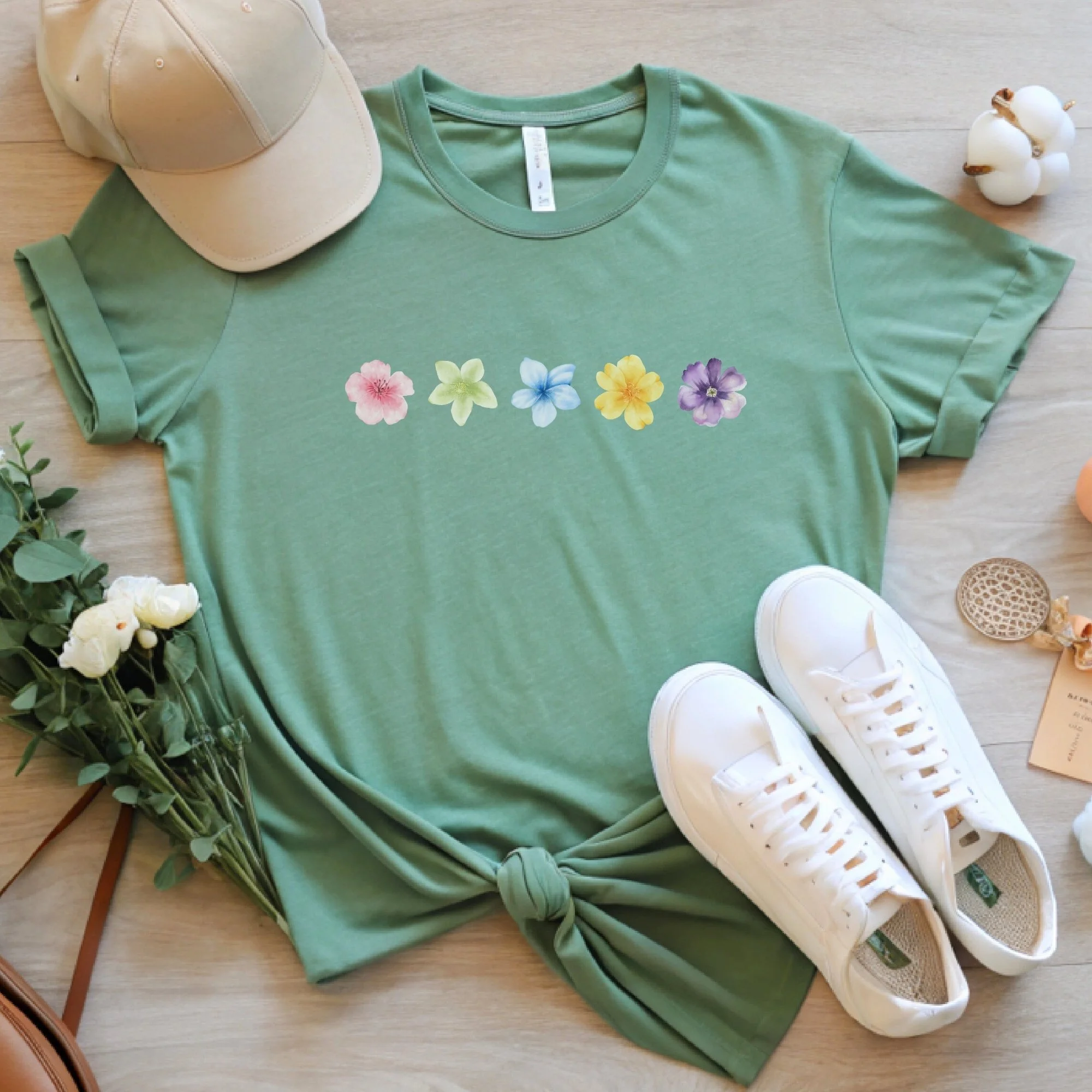Daytime styled view of Floral Wildflower graphic shirt on sage green tee with jeans, sneakers, and spring accessories