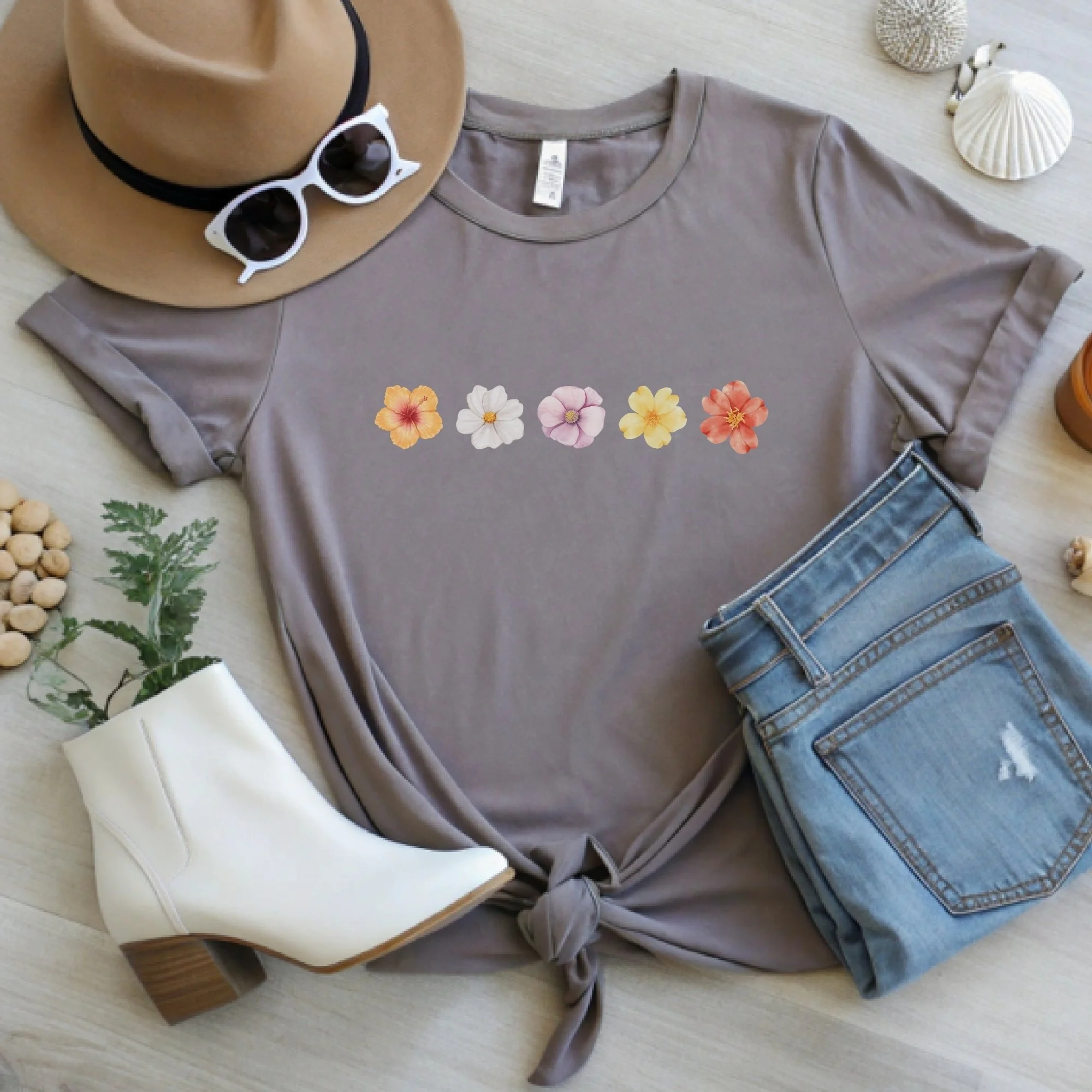 Daytime styled view of Floral Wildflower graphic shirt on pebble brown tee with jeans, sneakers, and spring accessories