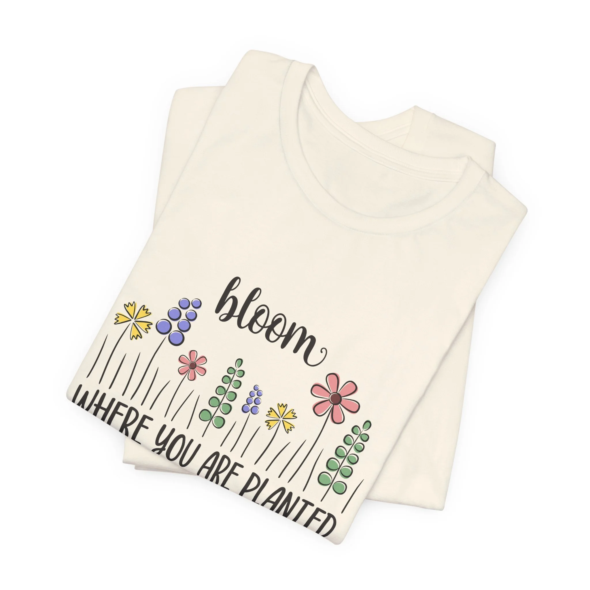 Folded natural cream t-shirt featuring Bloom Where You Are Planted graphic