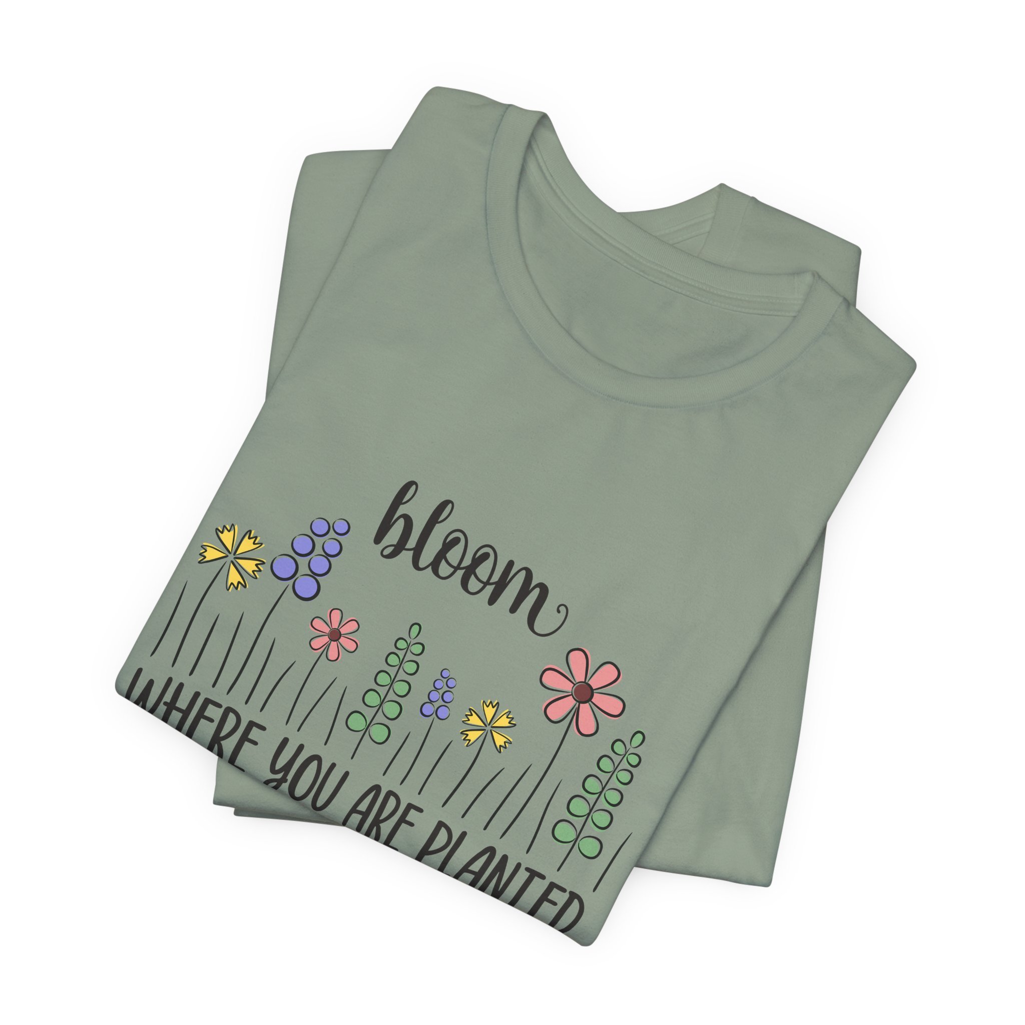 Folded sage green t-shirt featuring Bloom Where You Are Planted graphic
