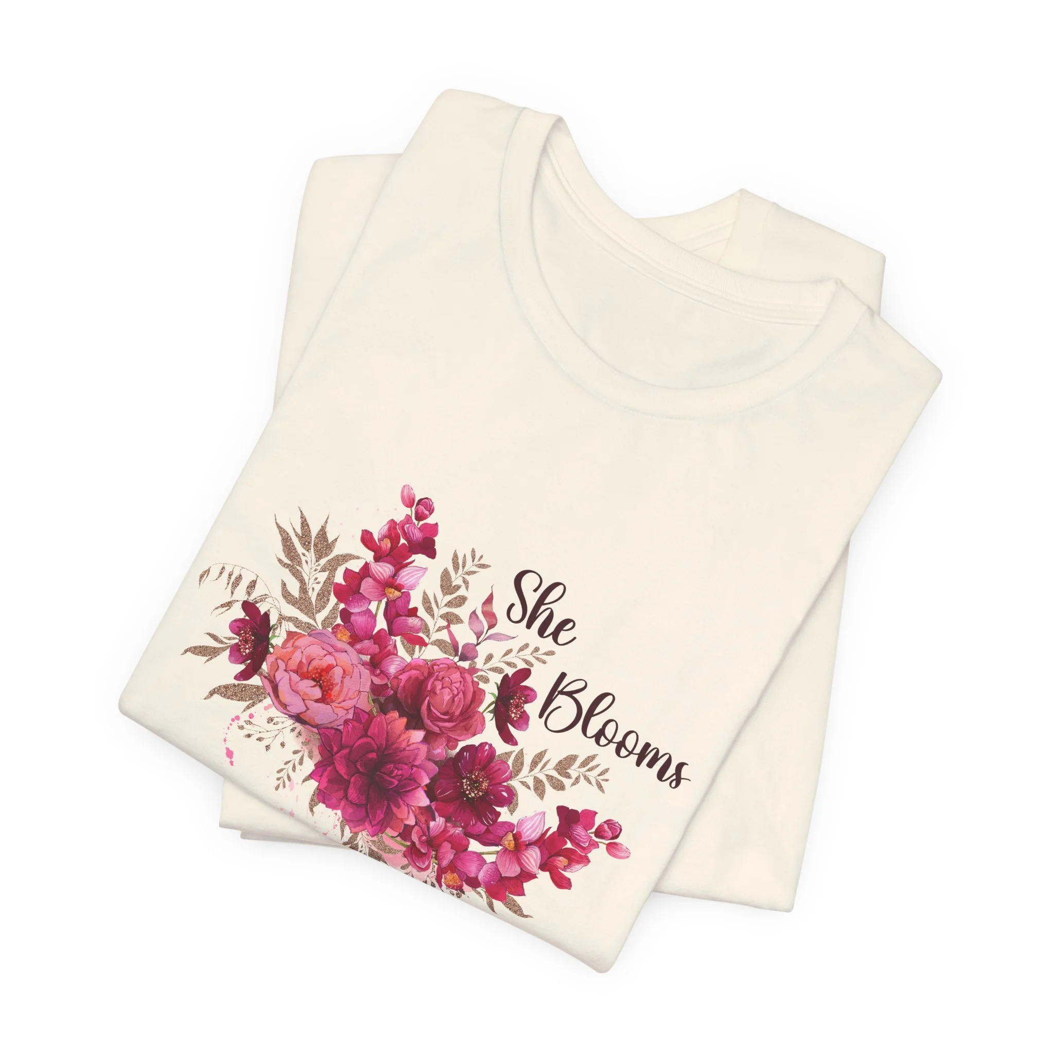 Folded natural cream t-shirt featuring She Blooms graphic