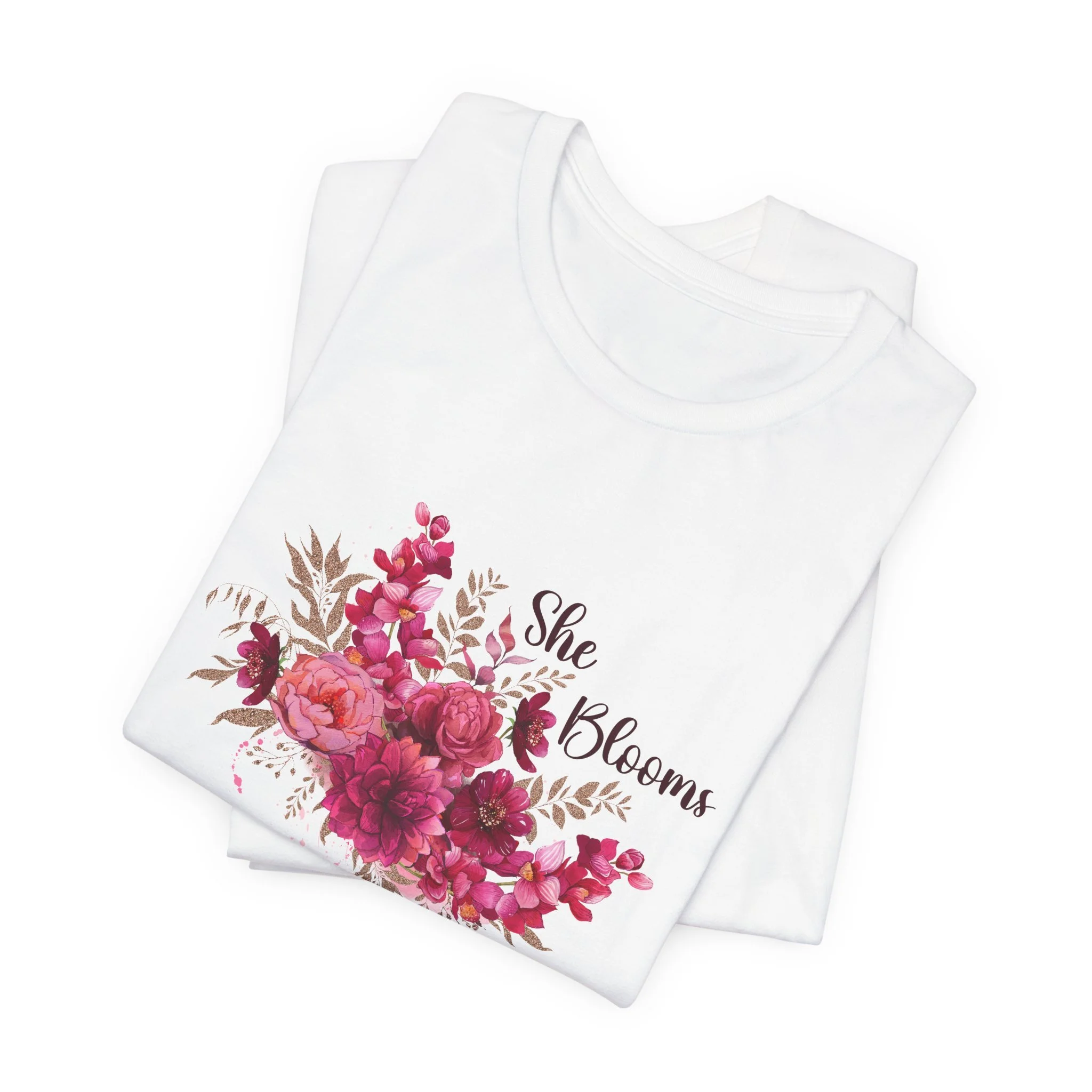 Folded white t-shirt featuring She Blooms graphic