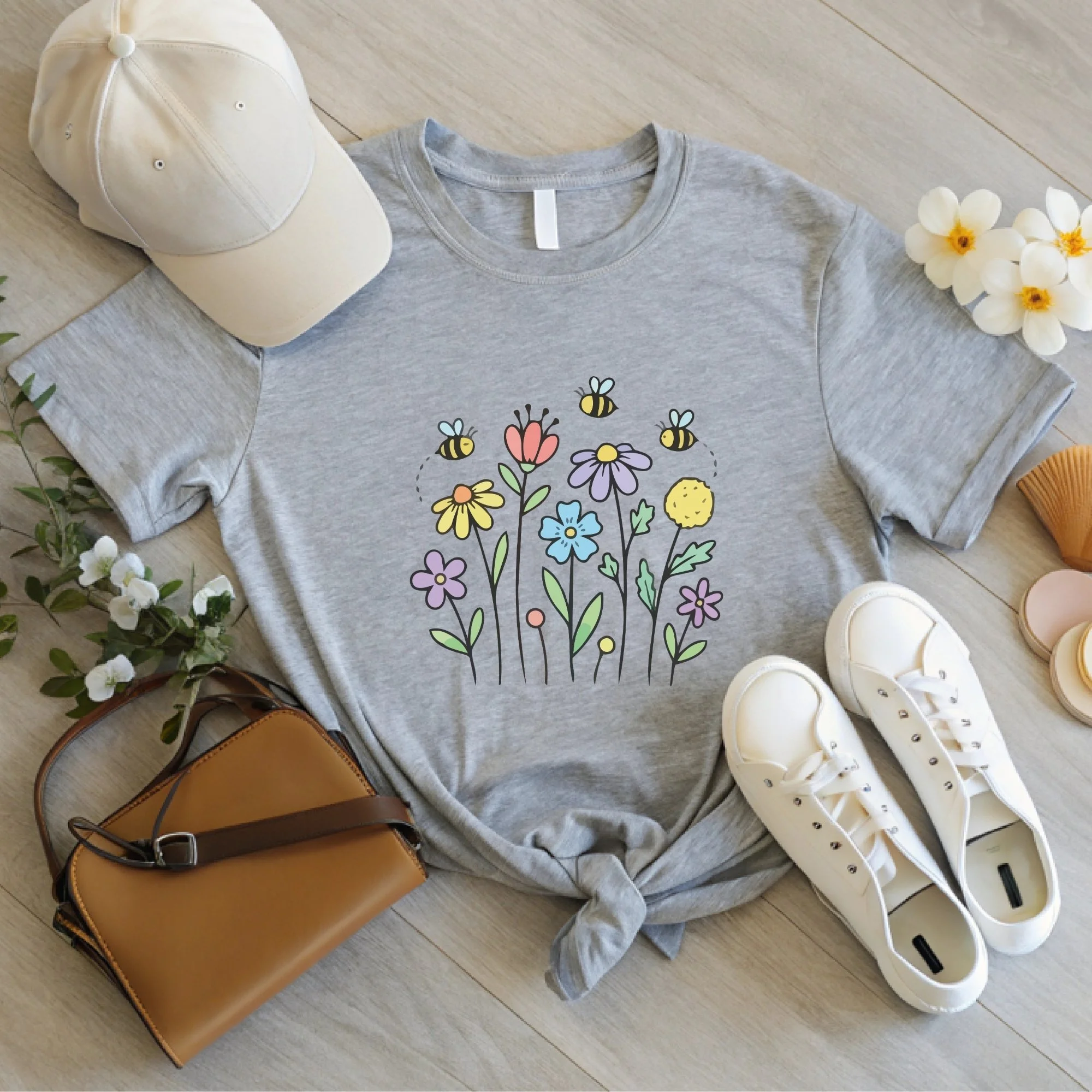 Daytime styled view of Bees and Flowers graphic shirt on ash gray tee with jeans, sneakers, and spring accessories