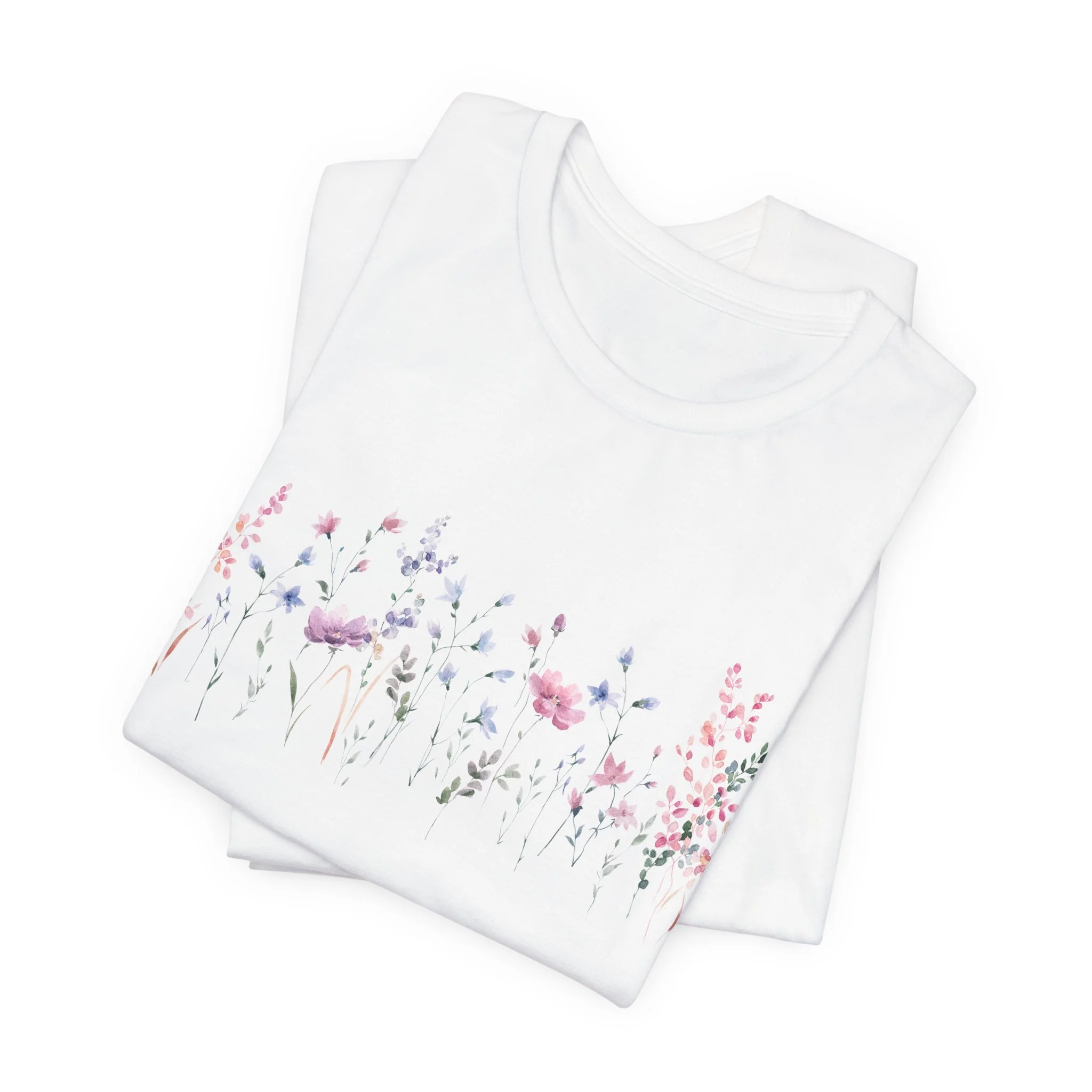 Folded white t-shirt with pastel watercolor wildflower border graphic