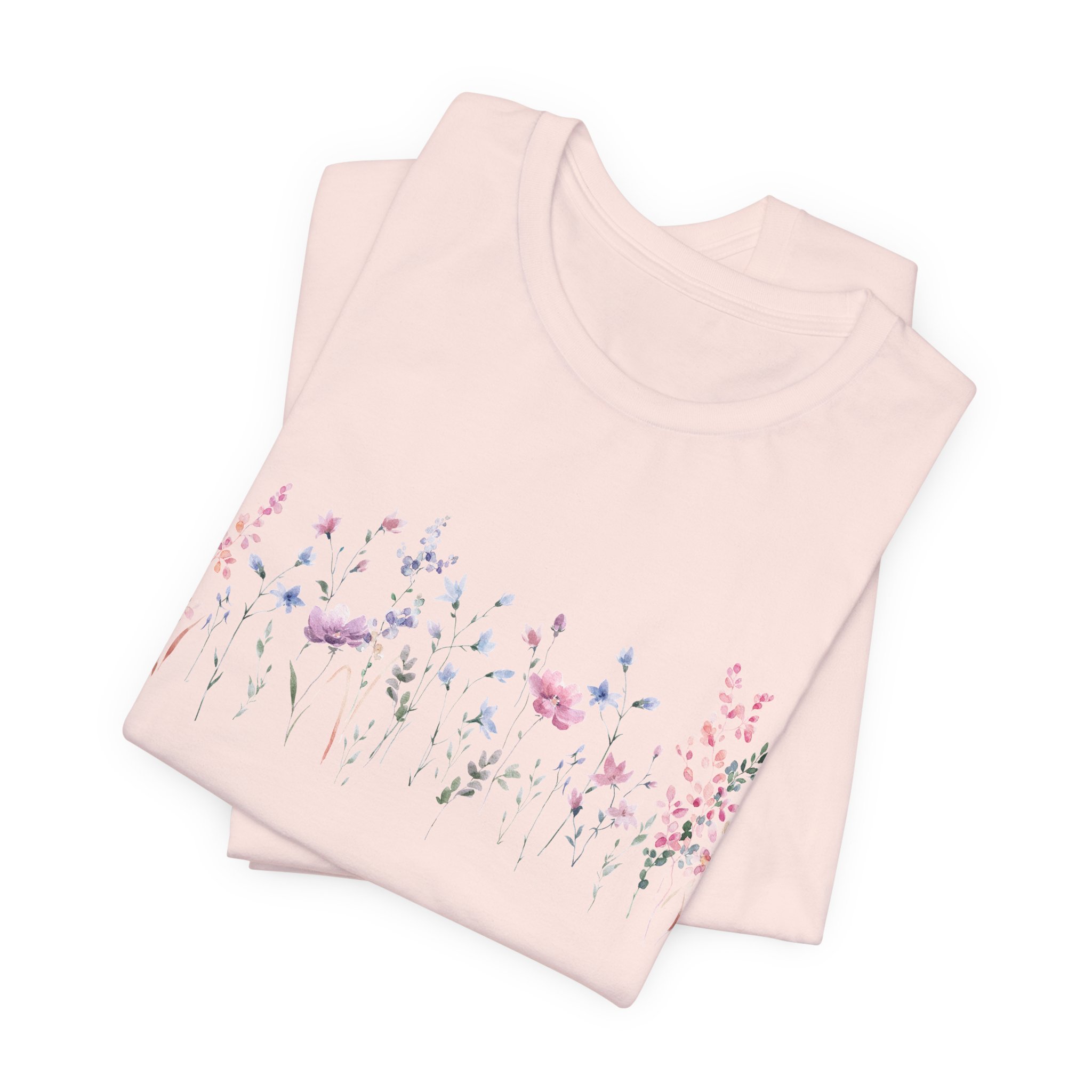 Folded soft pink t-shirt with pastel wildflower border illustration