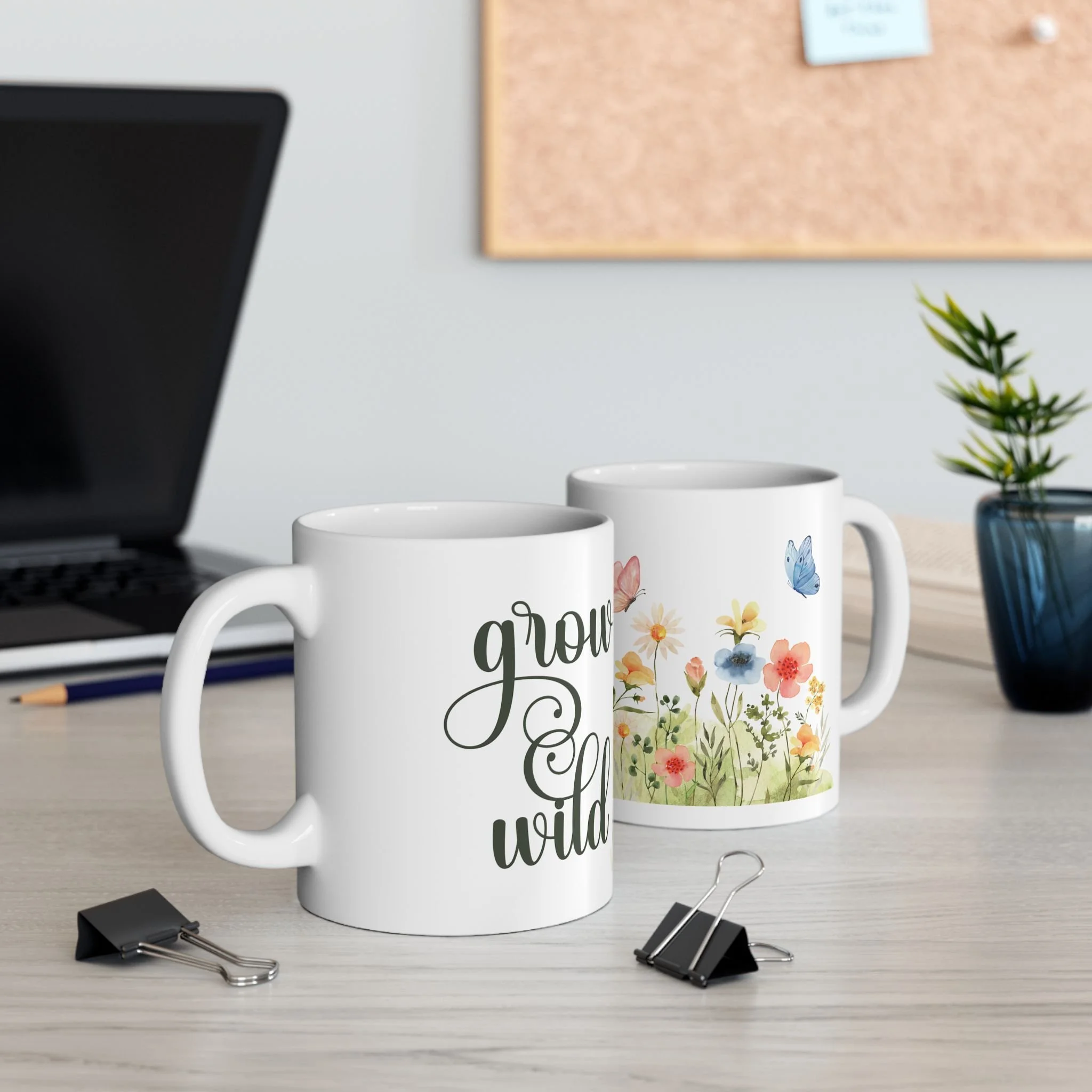 Styled desk scene with two grow wild floral mugs featuring wildflowers and butterfly design