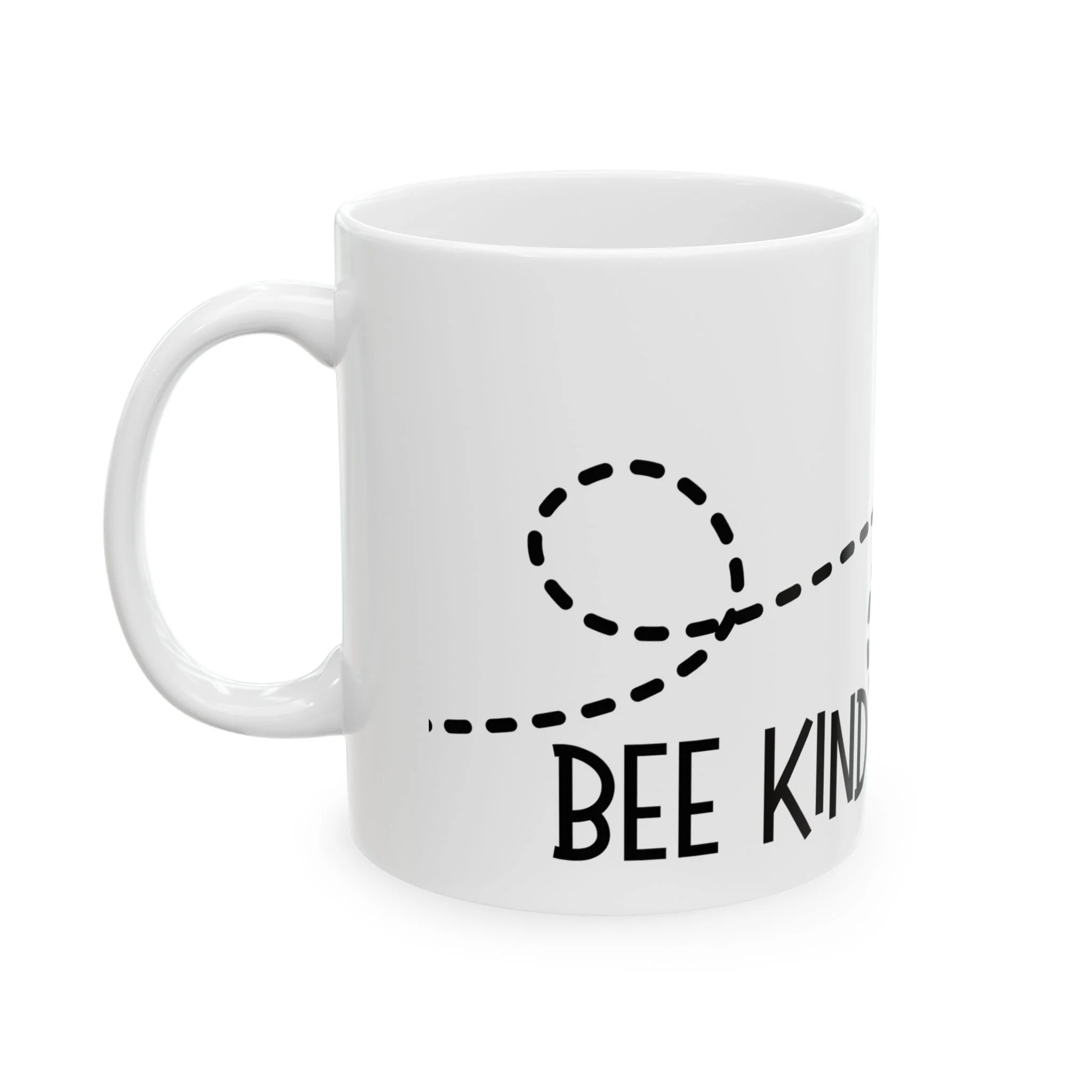 Front view of white ceramic mug with bee kind text and looping dotted line