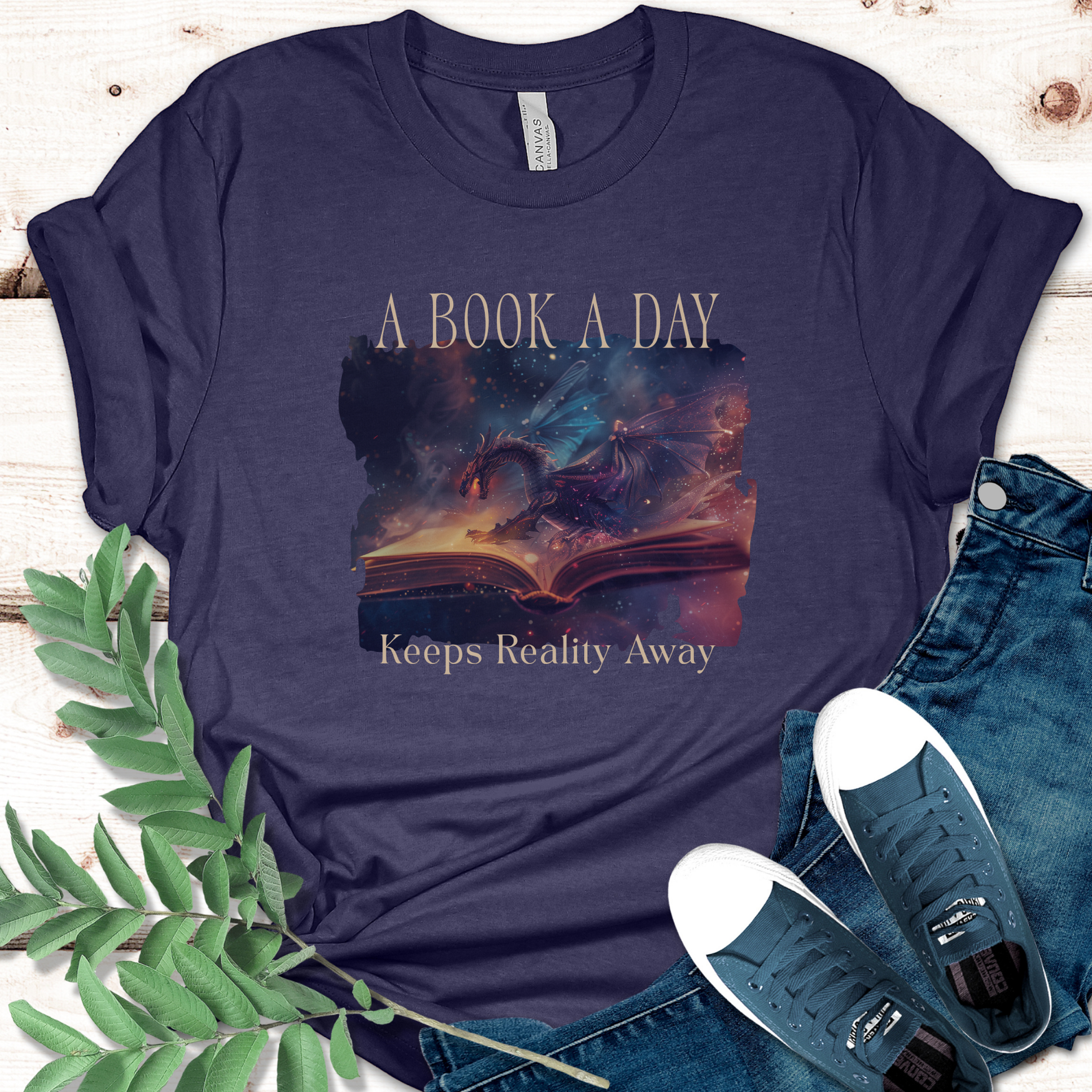 Fantasy book lover t-shirt with "A Book a Day Keeps Reality Away" graphic displayed on navy shirt with jeans and sneakers.