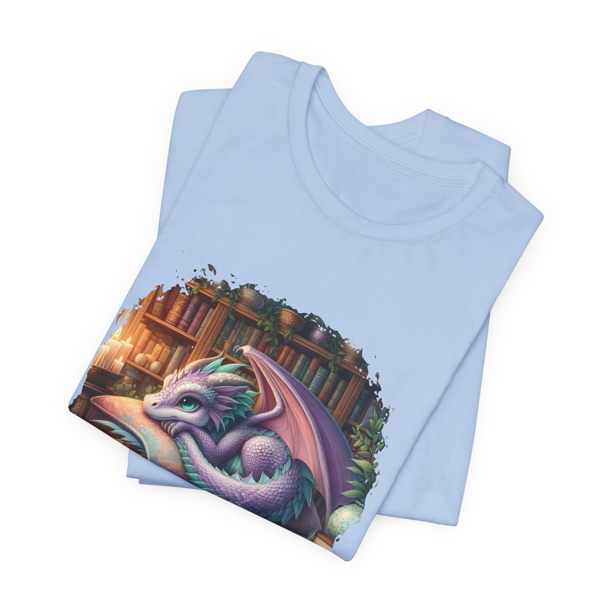 Folded pastel blue dragon book lover shirt with whimsical library artwork and colorful details.