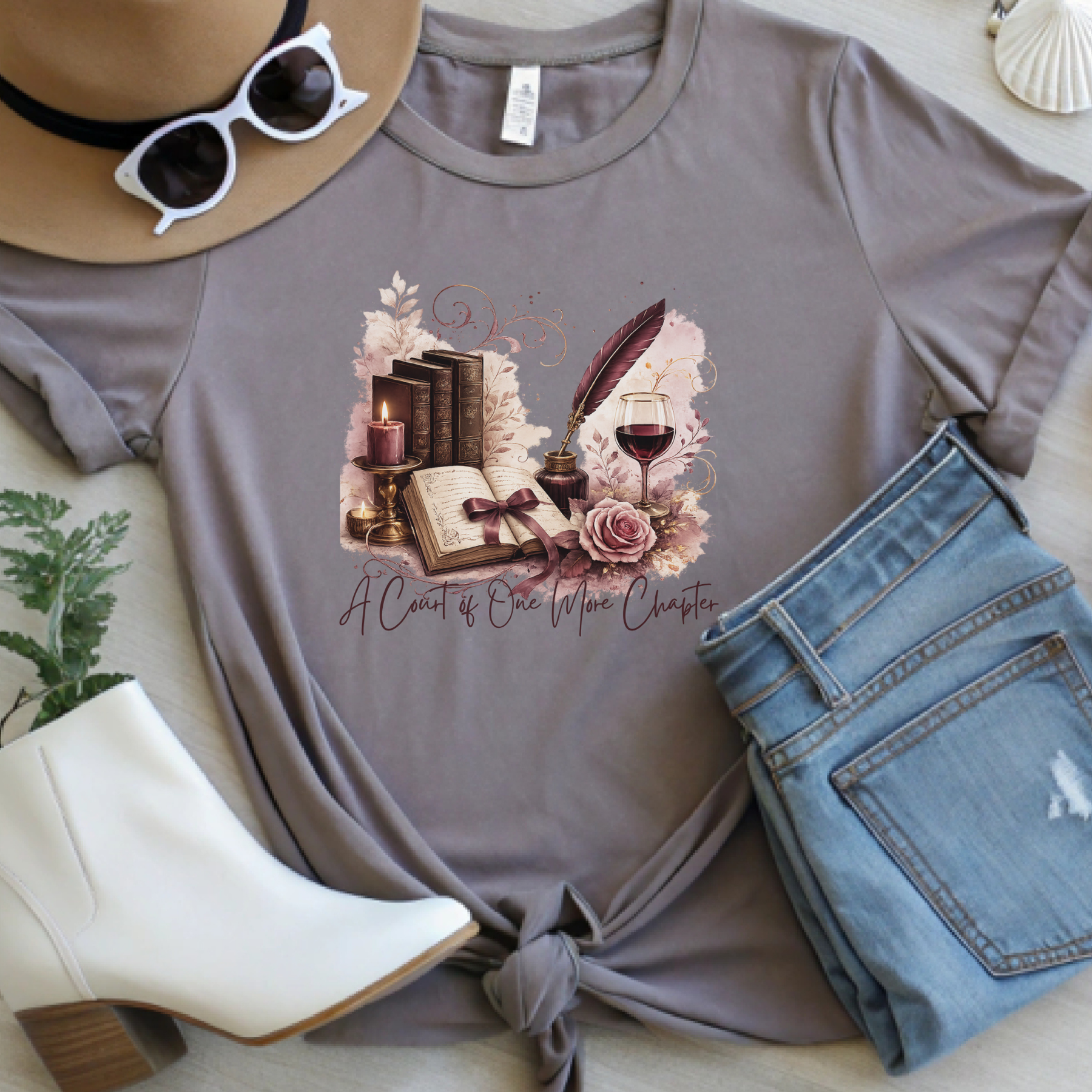 Pebble brown book lover t-shirt featuring vintage books, a feather quill, wine glass, and the phrase "A Court of One More Chapter."