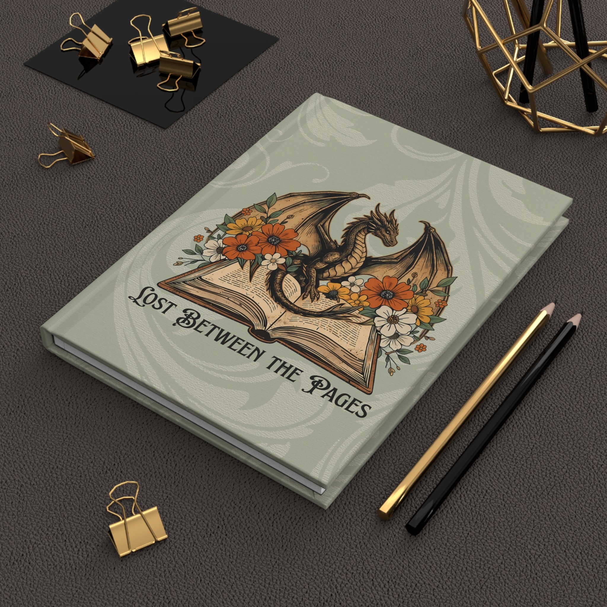 Fantasy dragon hardcover notebook displayed on a desk with coffee and stationery.