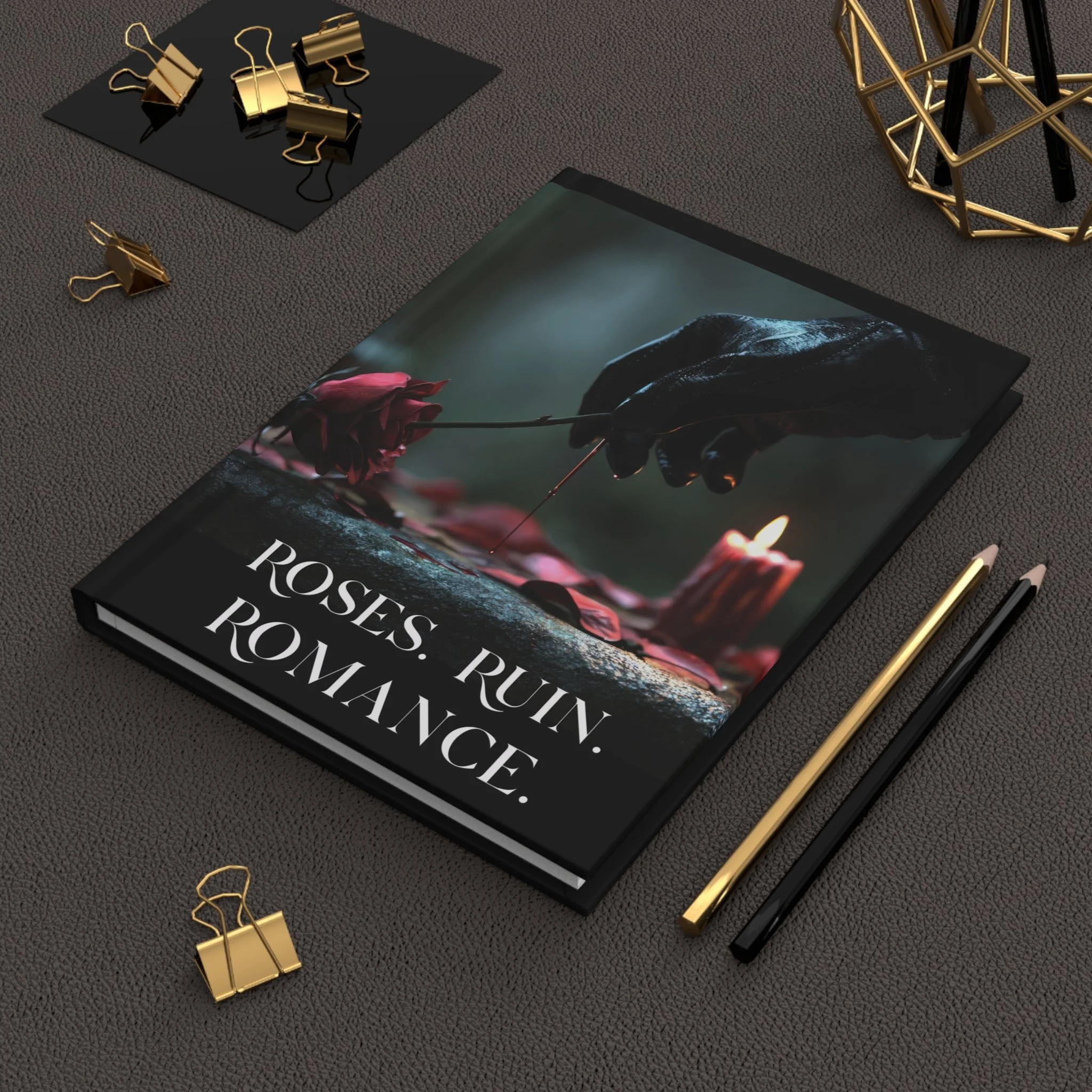 Roses Ruin Romance hardcover journal on a desk with pens