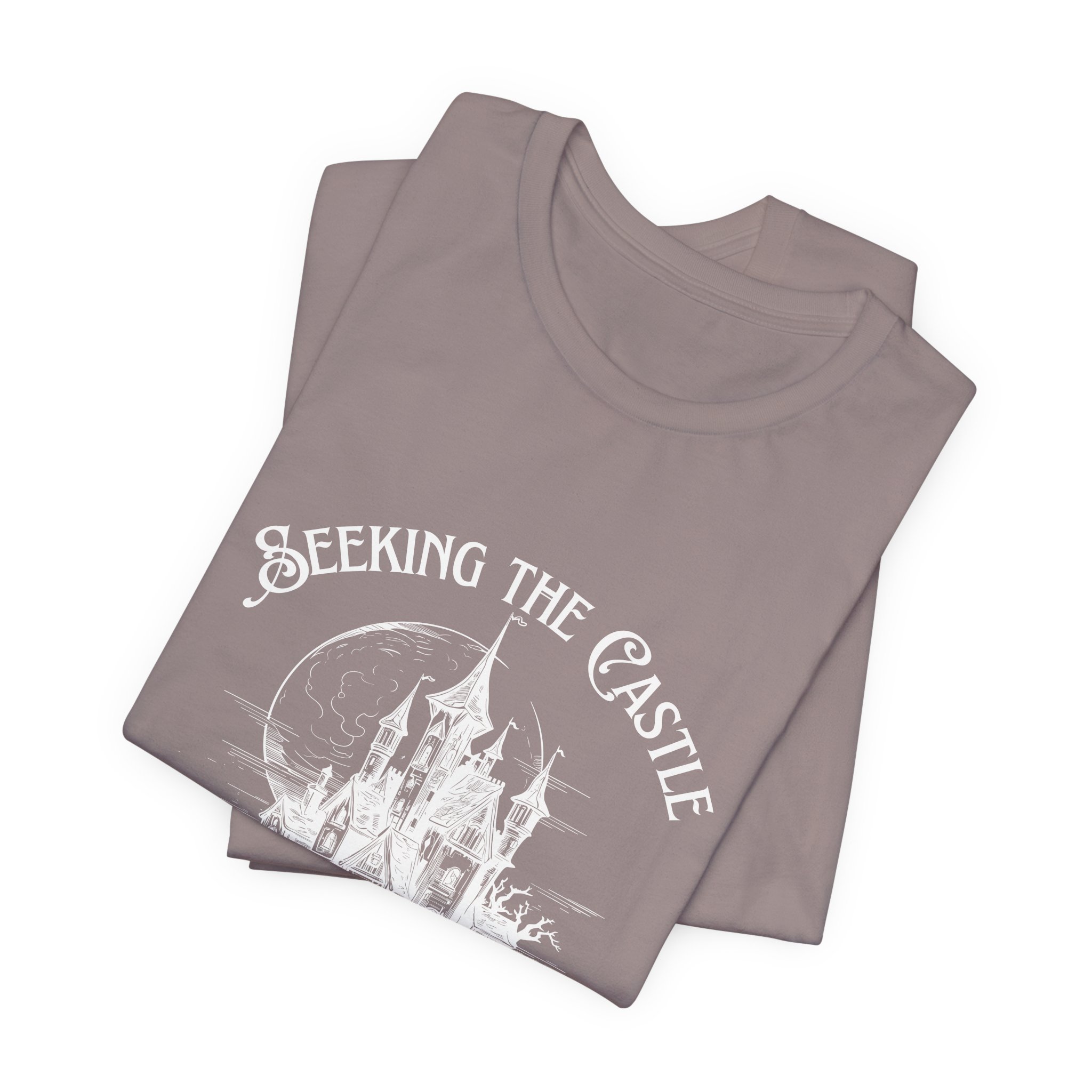 Folded Pebble Brown Bella+Canvas t-shirt featuring the "Seeking the Castle, Finding the Madness" fantasy castle design.