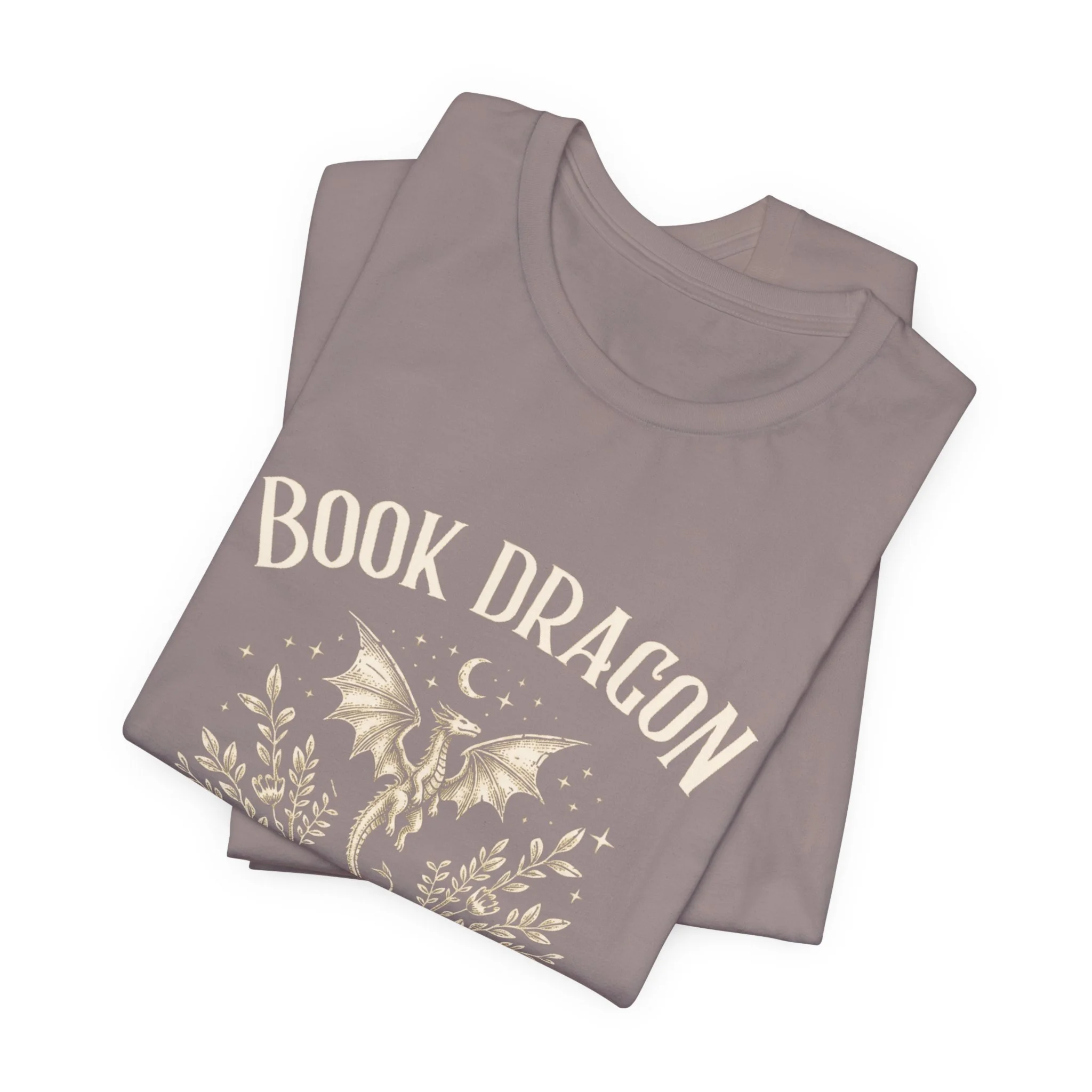 Folded Pebble Brown Bella+Canvas t-shirt featuring the "Book Dragon" fantasy graphic.