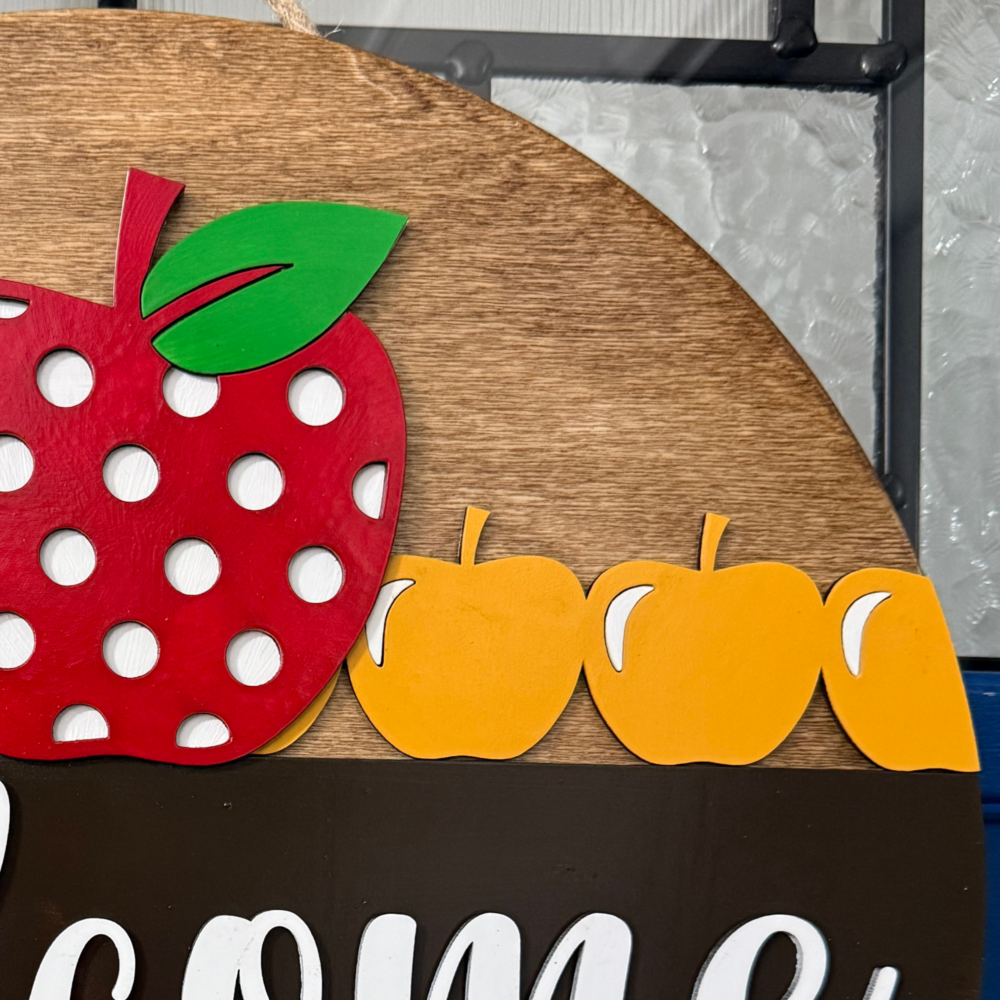 Close-up of red apple with white polka dots and green leaf detail