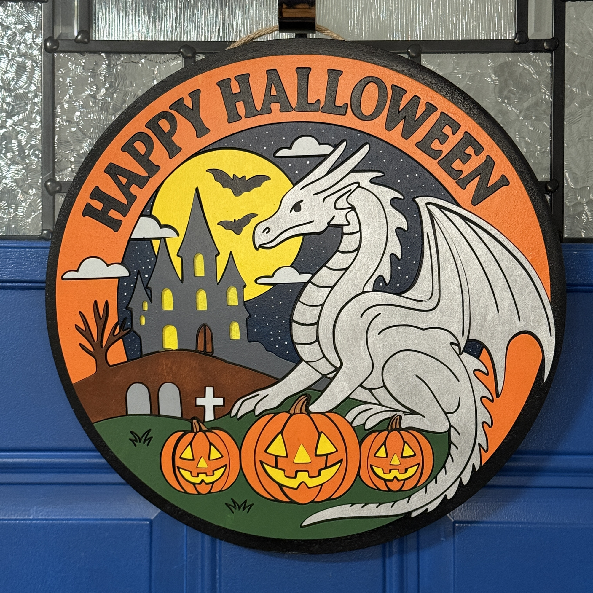 Front view of Halloween dragon door hanger with silver dragon, pumpkins, haunted castle, and “Happy Halloween” text