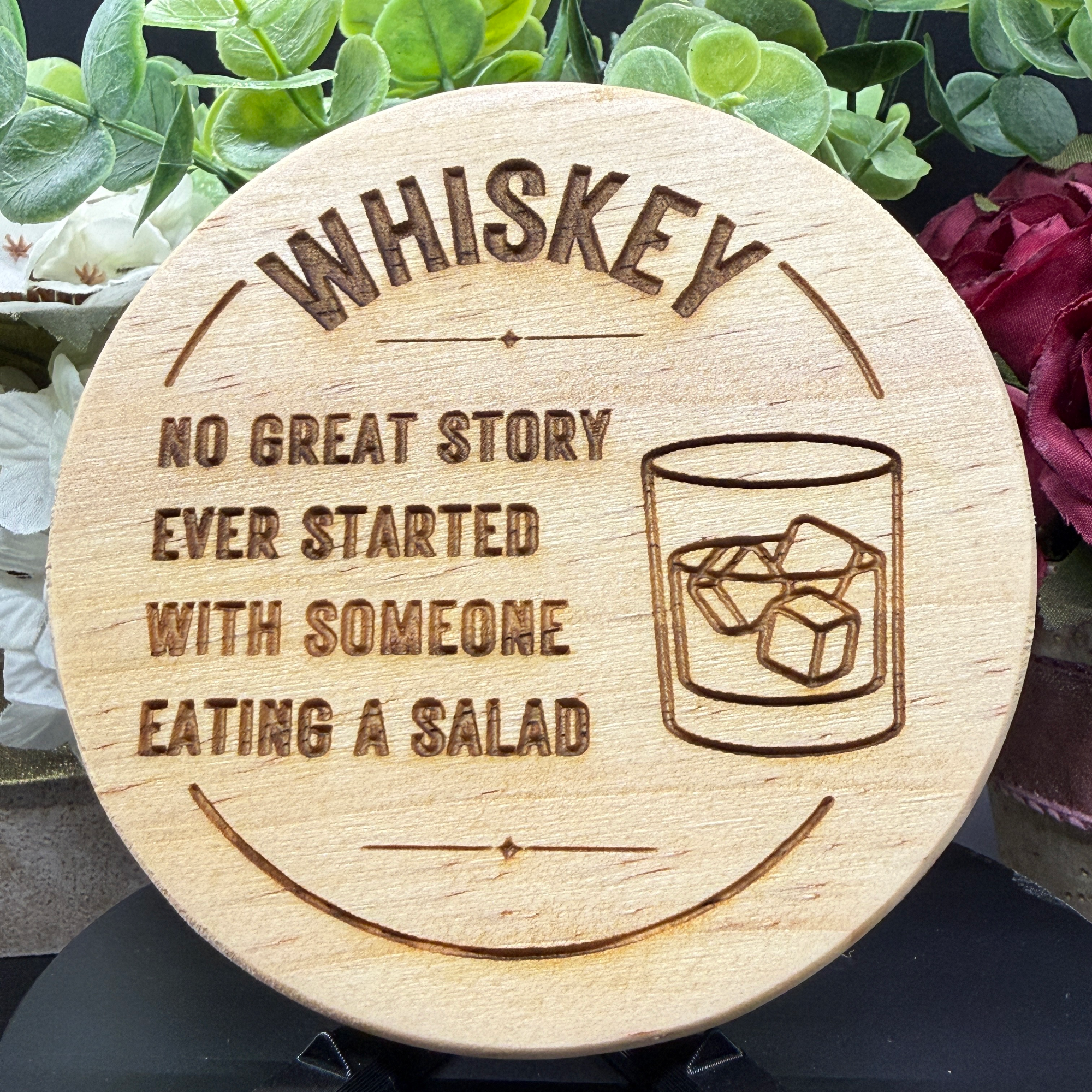 Whiskey quote coaster with engraved glass and ice cubes